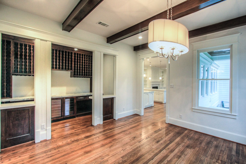 Large dining area also has an unobstructed view of the nature trail with stained ceiling beams, art wall between the windows, and a designer fixture. Lighting here and elsewhere dimmable to 5%.
