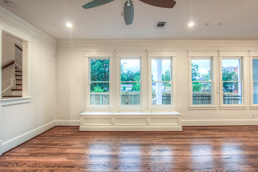 The living area downstairs has built-in window seating and a fireplace surrounded by shelving and marble tiles.