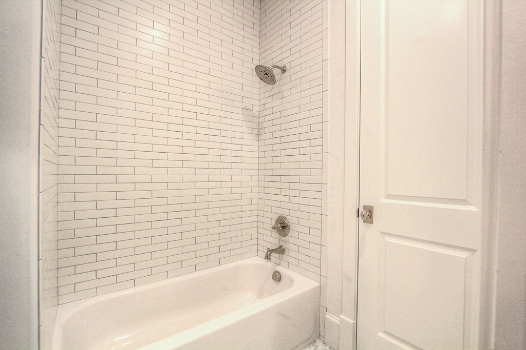 This secondary bathroom has beautiful glass tile in the tub.