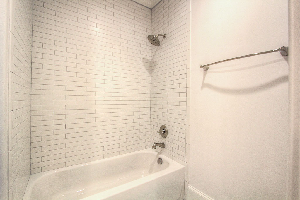 This secondary bathroom has beautiful glass tile in the tub.