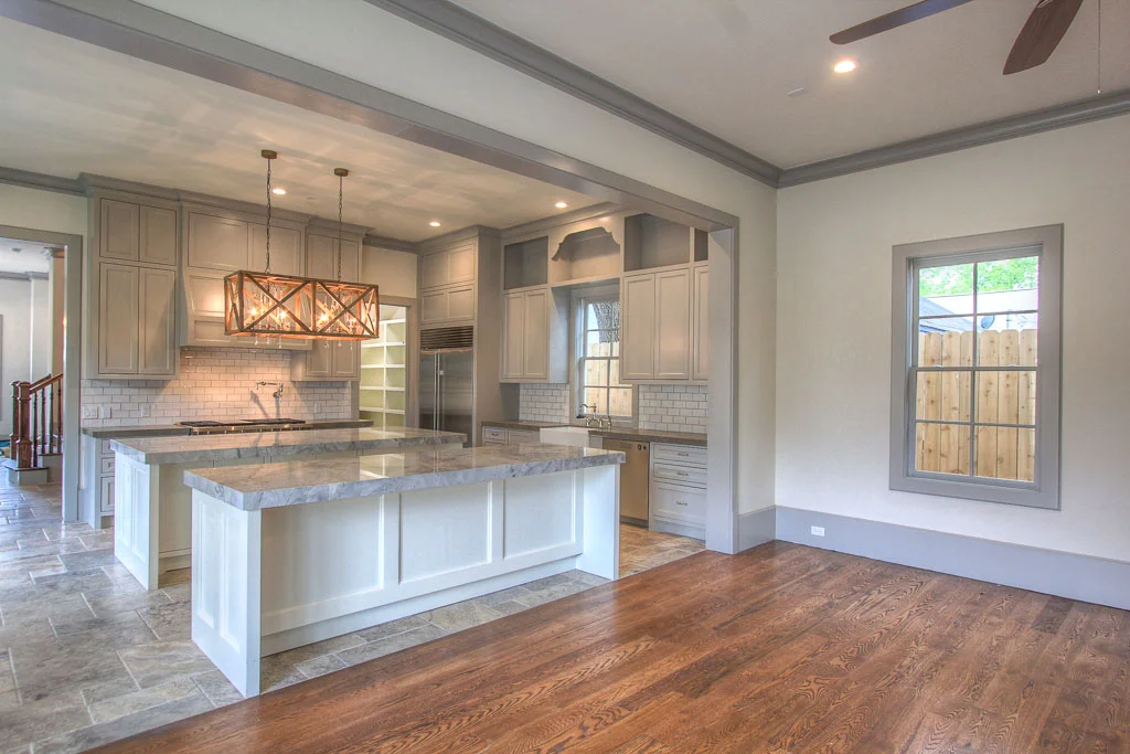 Kitchen w/ dual Super White Quartz islands will be the heart of the home, w/ island seating adjacent to great room. Walker Zanger tile. Rustic and refined is a noticeable theme: Versailles pattern Travertine, wide-plank hardwood, limestone counters.
