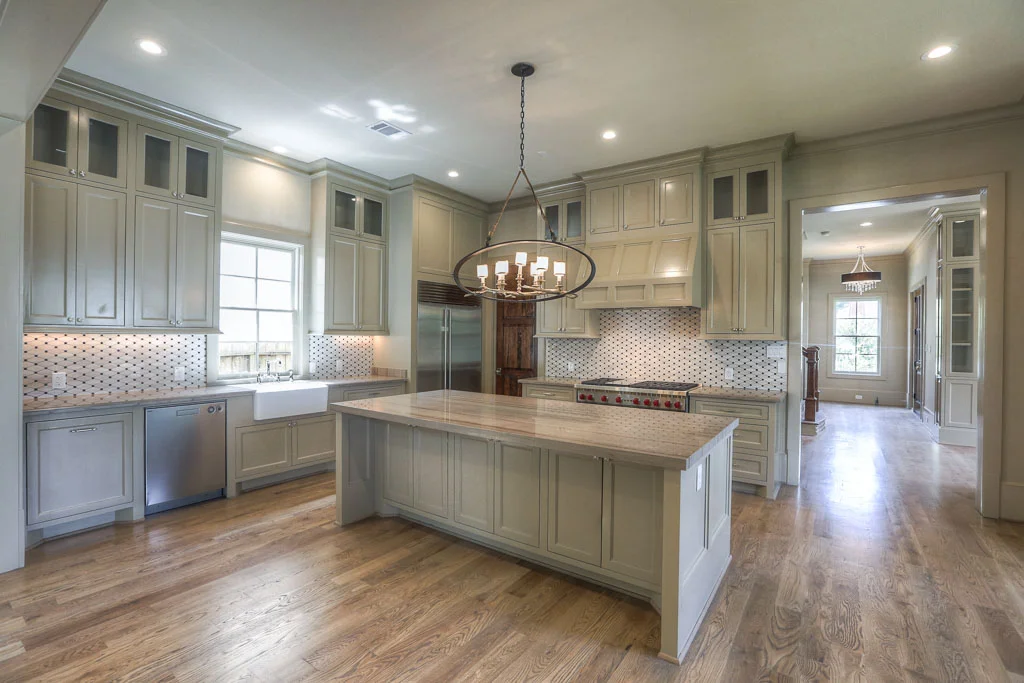 The large, open kitchen has a warm feel. The over-sized island has seating for everyday gathering, and the Wolf Performance appliances and 48" Sub Zero refrigerator make it chef's dream to cook.