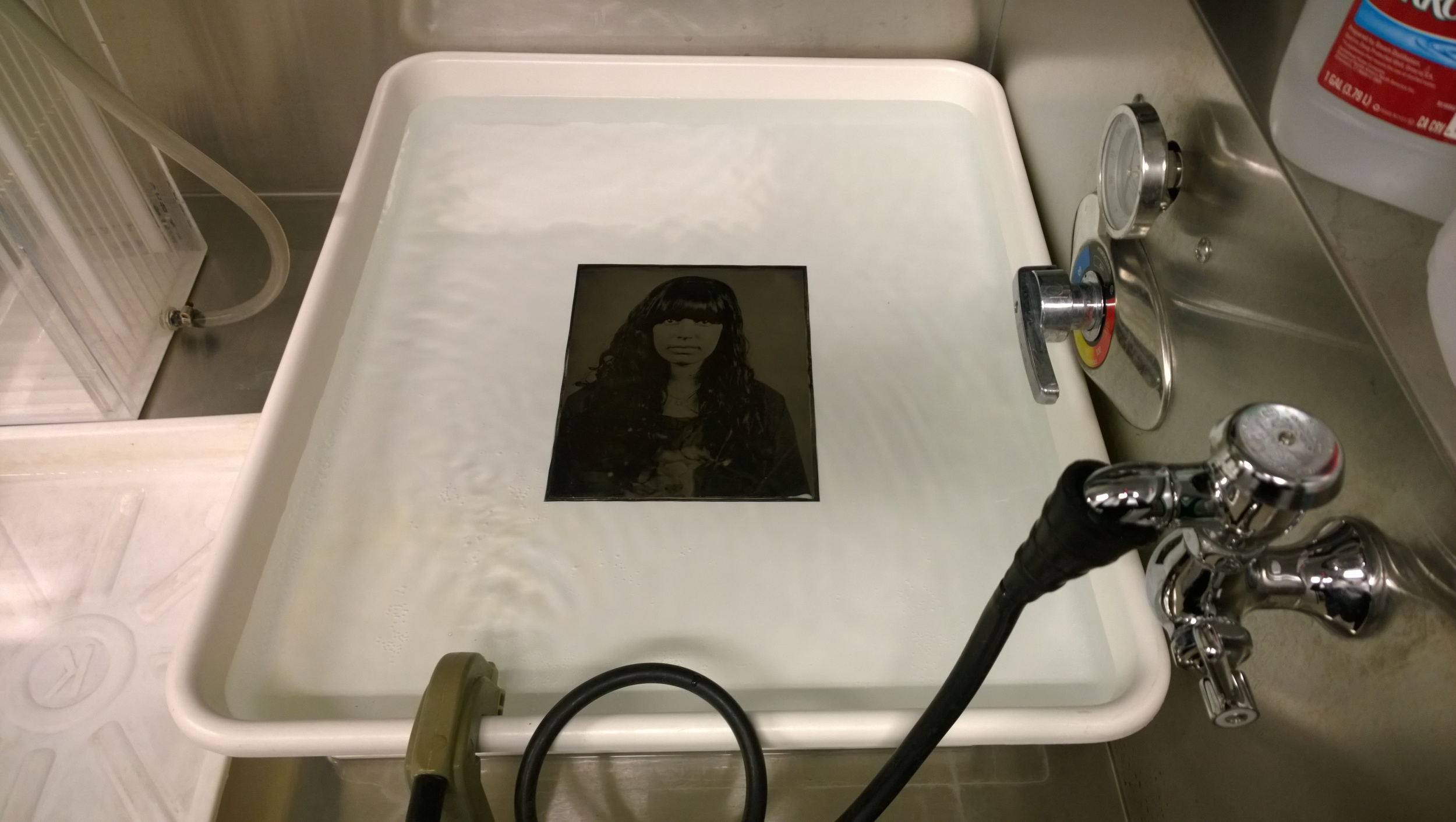 A tintype sits in the wash after developing.