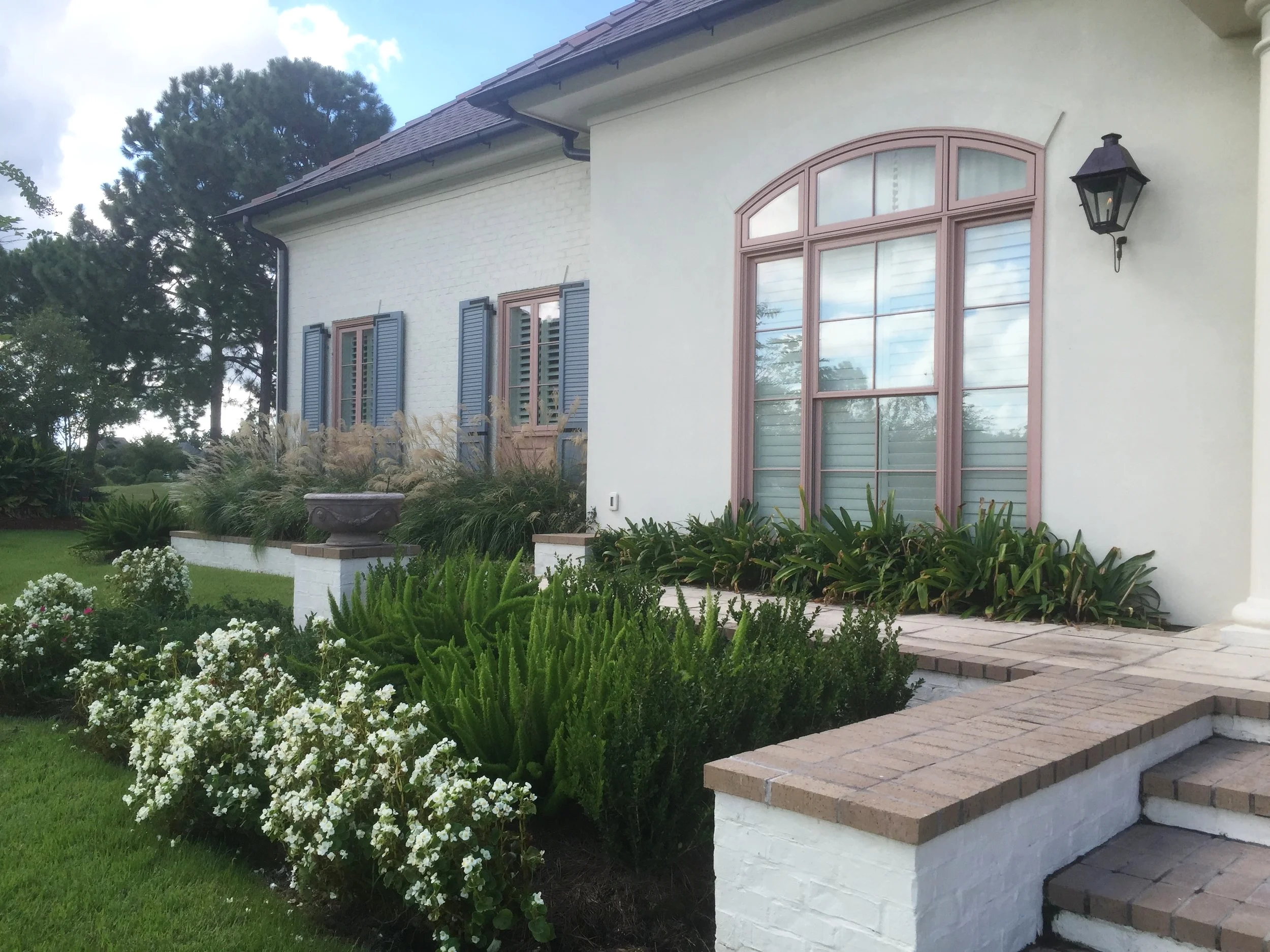 Front of house features tiered planters and a variety of cottage-inspired textures and colors. 