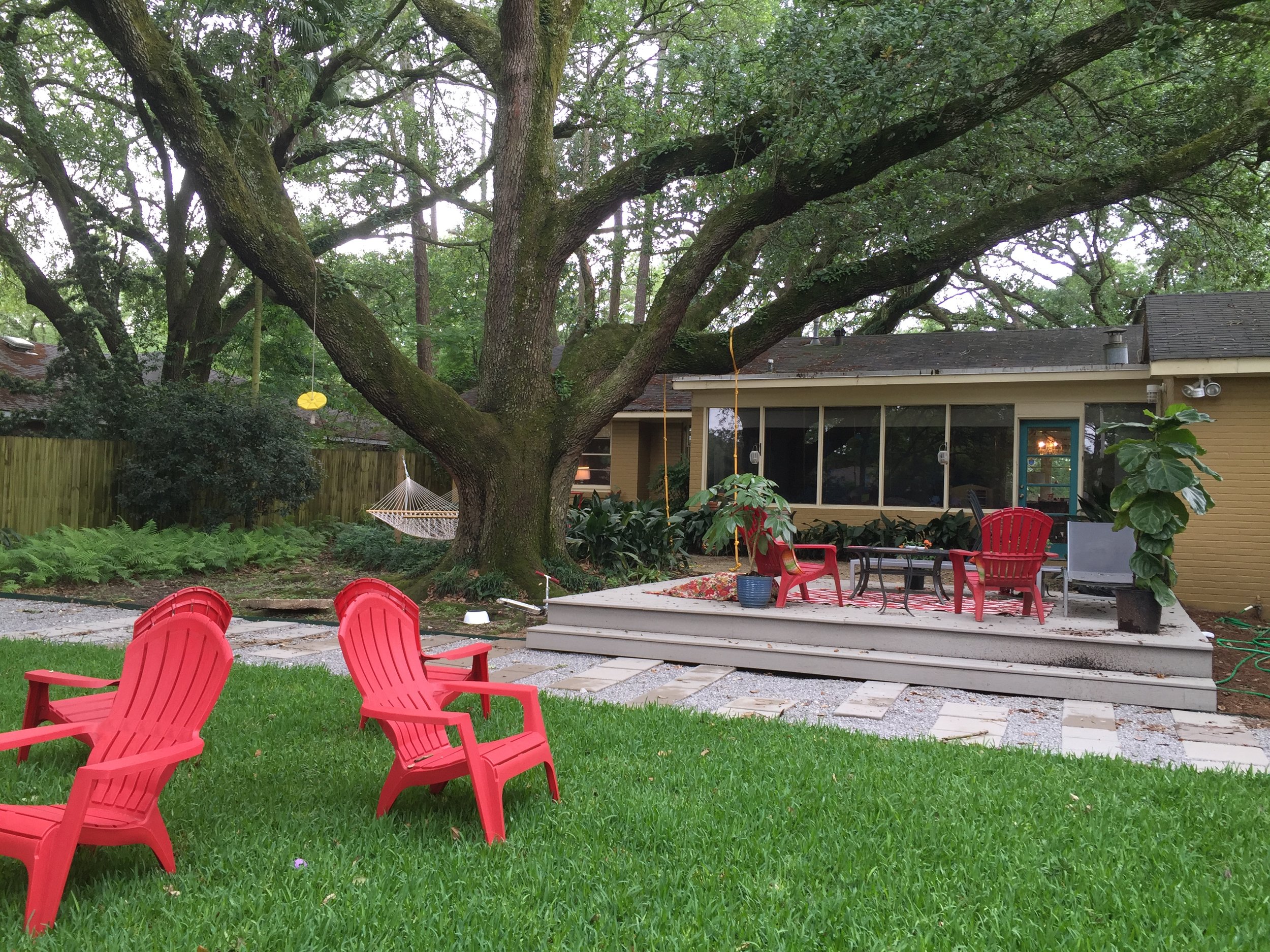 the back yard showcases the large oak tree and plenty of seating areas for the family.