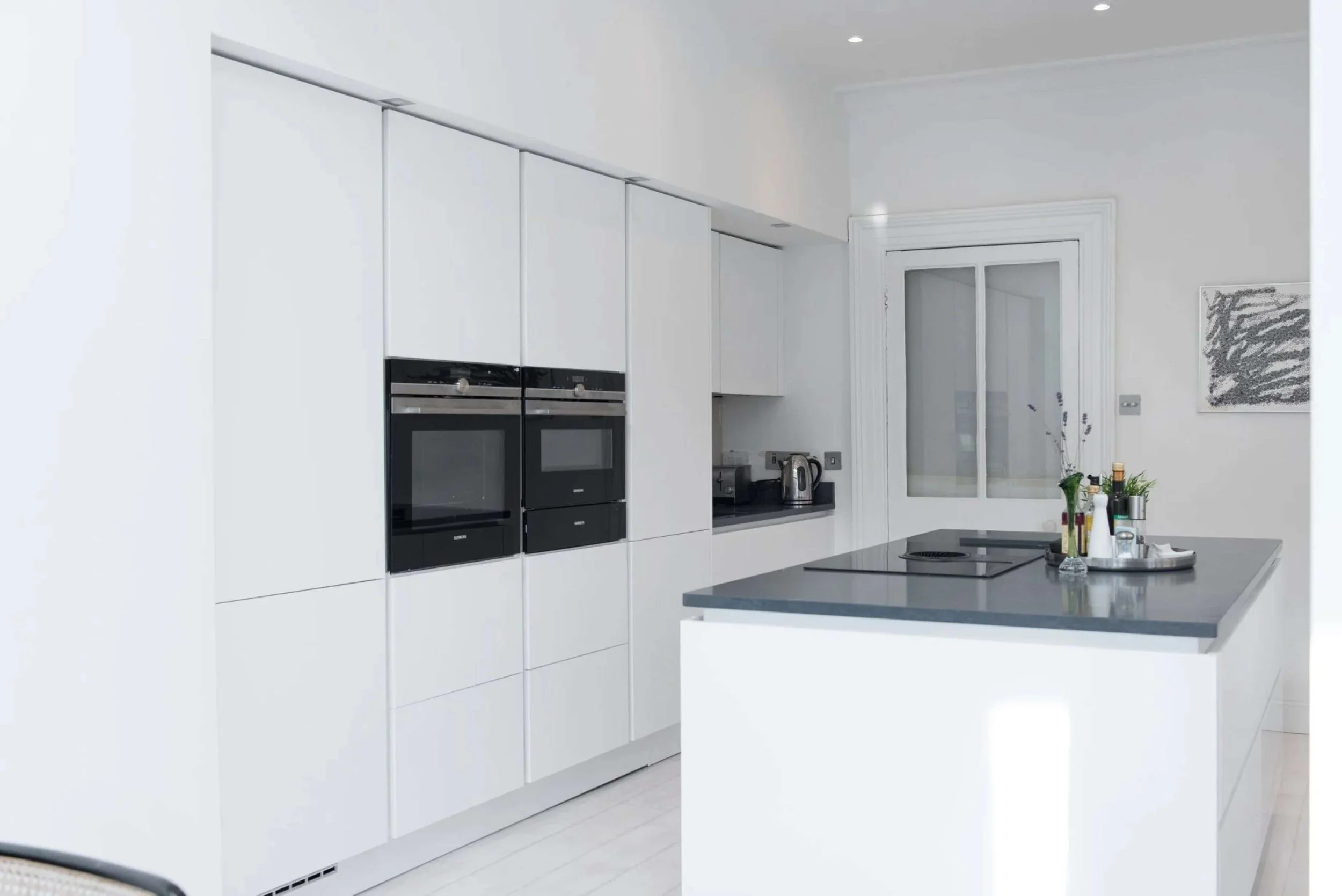 Crisp white super-matte modern kitchen in period Blackrock, Dublin home.