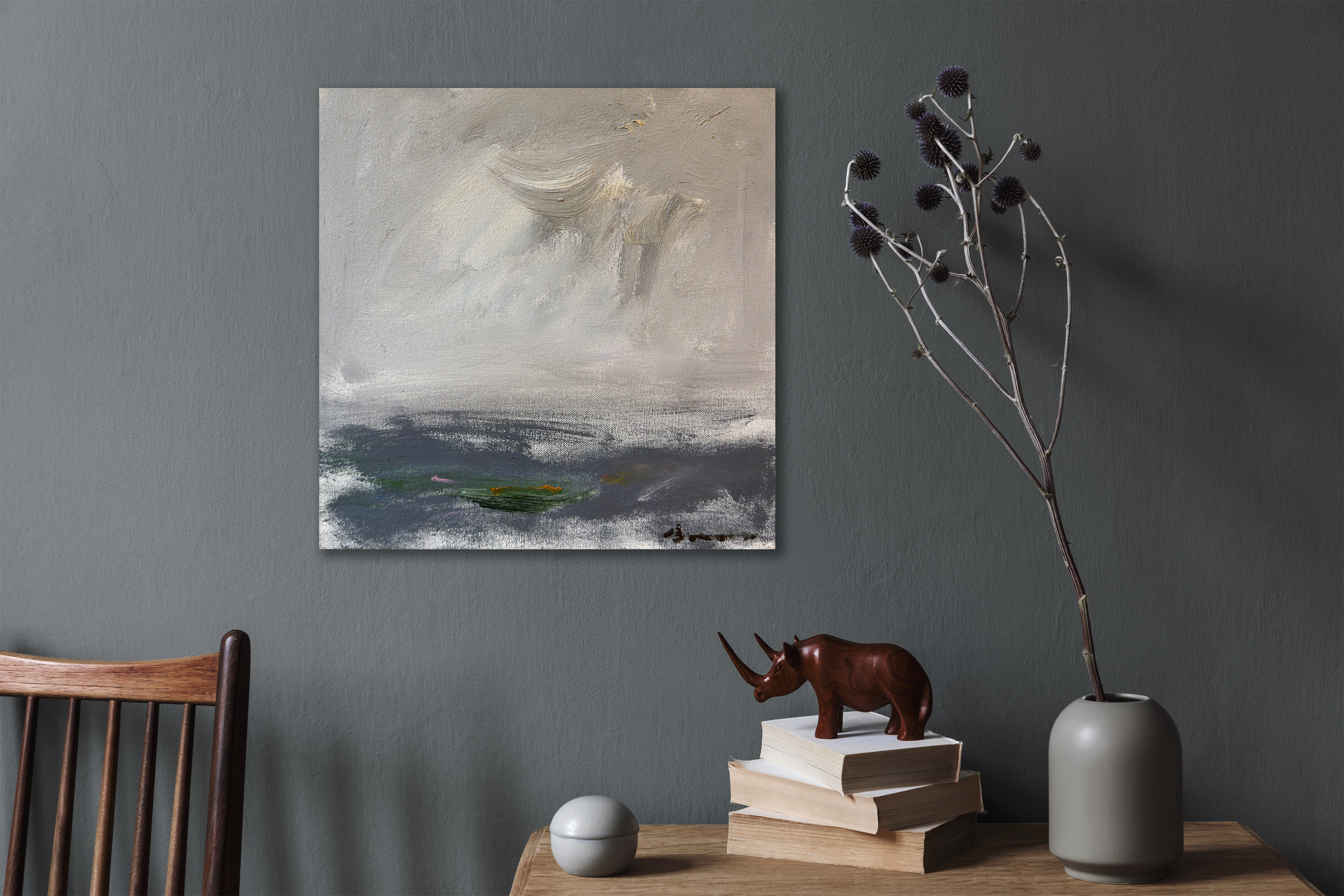 Abstract seascape painting above a styled wooden table with books and decor.