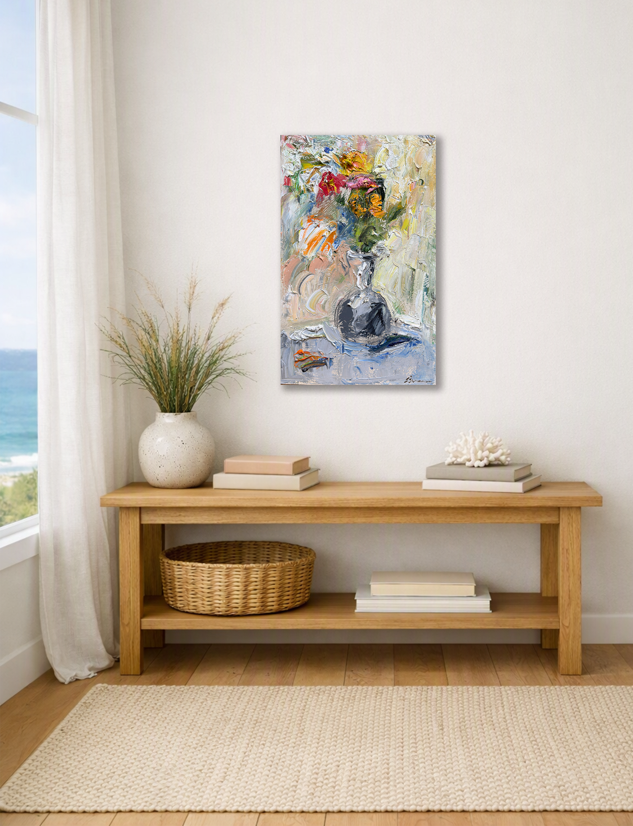 Abstract floral painting above a wooden console table with books, decor, and a woven basket.