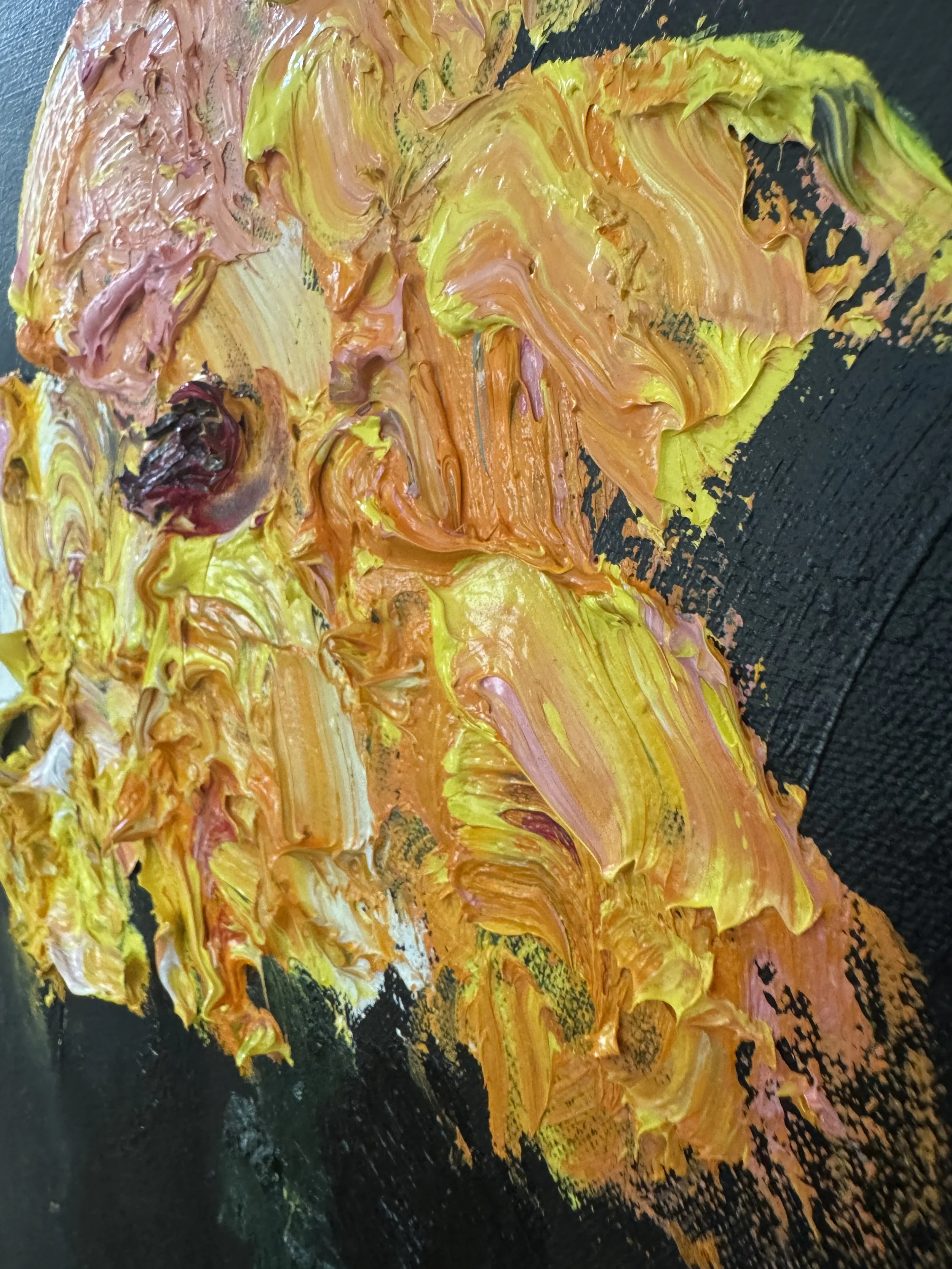 Textured close‑up of layered yellow, orange, peach, and purple paint against a dark background.