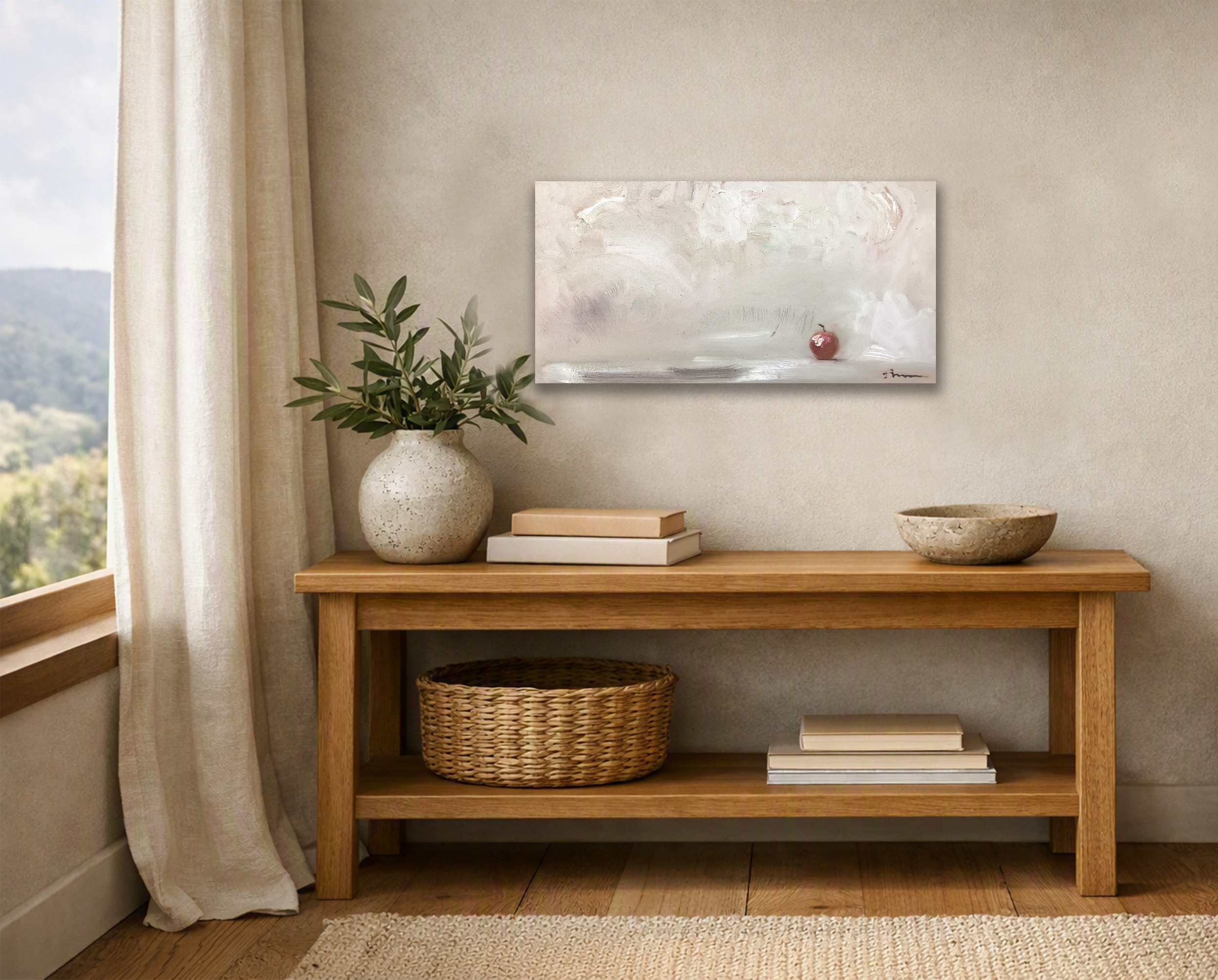 Abstract apple painting above a wooden console with ceramic vase, books, and woven basket in a warm minimalist room.