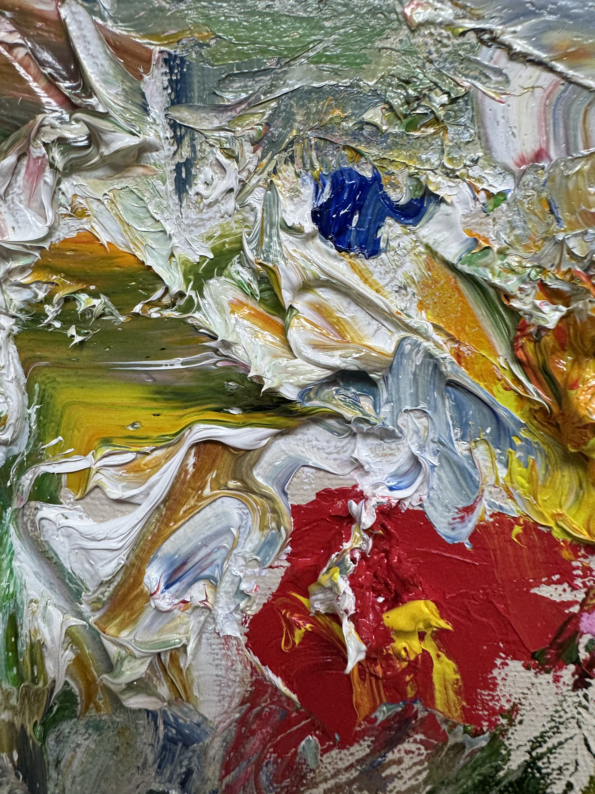 Close-up of thick, textured abstract oil paint in bold mixed colors.