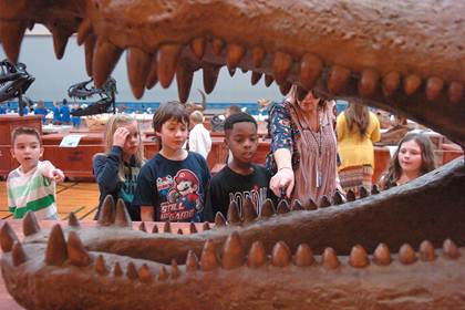 Looking at the mouth of a prehistoric alligator are Tyler Chancler, Baylie Cole, CJ McCabe-Green, J'tavon Ferguson, 2 nd grade teacher Debbie Allred, and Kylie Crawford.