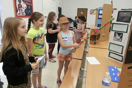 Lilly Boudrie points out the characteristics of alligators and jerboas to Julie Dyck (left) and Jennifer Frieson.
