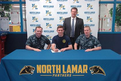Trevor Burns, center, with Petty Officer Sam Money, left, Petty Officer Christopher Gault, right, and NLHS Principal Clint Hildreth, standing.