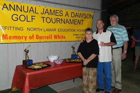 Sandra and Wade White, wife and son of the late Darrell White, stand with James A. Dawson at the Saturday Night Social and Auction following a golf tournament benefitting the North Lamar Education Foundation.