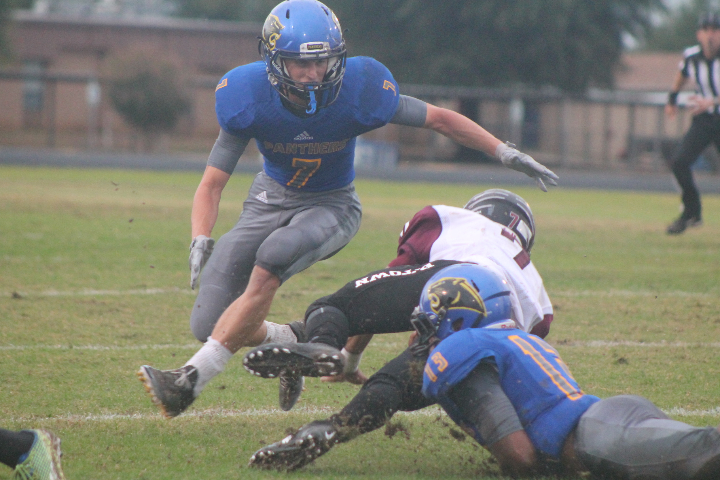 (Photo by Maddy Routon) Seybian Holt (13) and Trey Scudder (7) Making a tackle on a Princeton player Friday night.