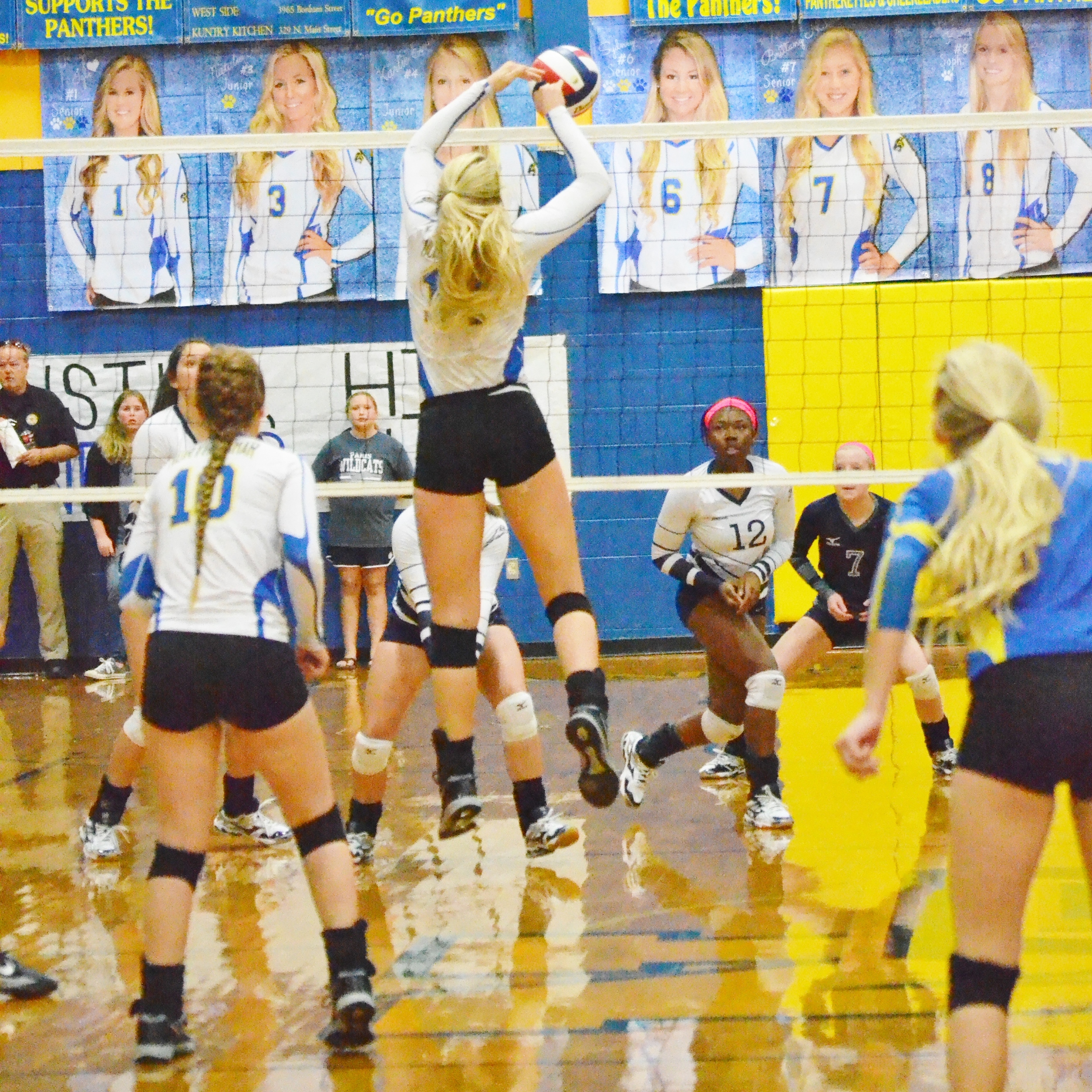 (Photo by Beverly White) Sydney Foy (14) hitting the ball at the net against Paris earlier this year while Bailee Nickerson (10) and Brittany Nichols (blue jersey) watch.
