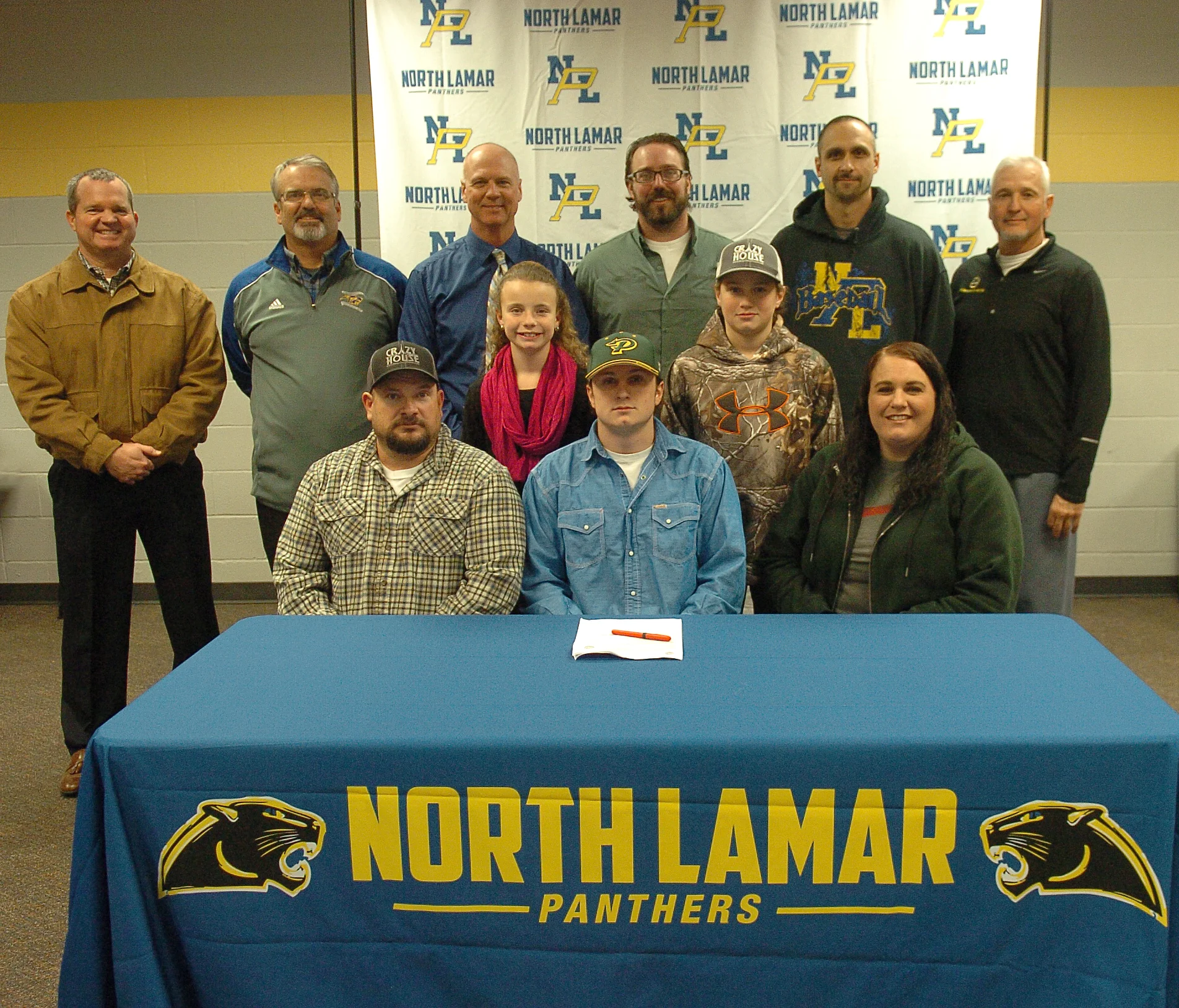 North Lamar’s Hunter Reeves , seated center, is joined by others as he signs to play baseball for the PJC Dragons. Seated with him are parents, Cody and Dana Reeves, along with siblings, Maddie and Gage, directly behind. Standing in back are NLISD Superintendent John McCullough, NL Head Baseball Coach Scott Igleheart, PJC Head Baseball Coach Deron Clark, PJC Assistant Coach Clay Cox, NL Assistant Coach Chad Chalupa, and NL Athletic Director Tim Billings.