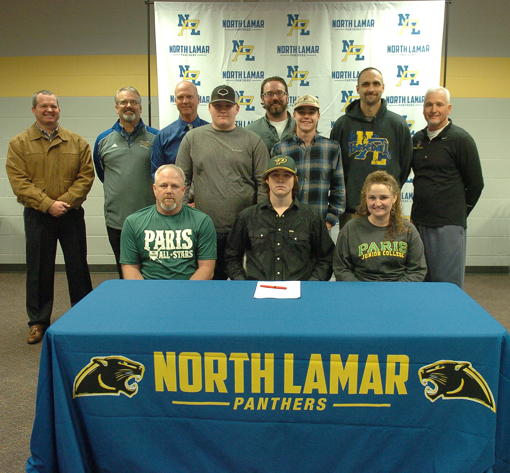 Seated with Kevin Dickey , center, as he signs to play baseball for the PJC Dragons are his parents Mickey and Terry Dickey and brothers standing behind, Cameron and Eric. Others joining on this momentous occasion are NLISD Superintendent John McCullough, NL Head Baseball Coach Scott Igleheart, PJC Head Baseball Coach Deron Clark, PJC Assistant Coach Clay Cox, NL Assistant Coach Chad Chalupa, and NL Athletic Director Tim Billings. 