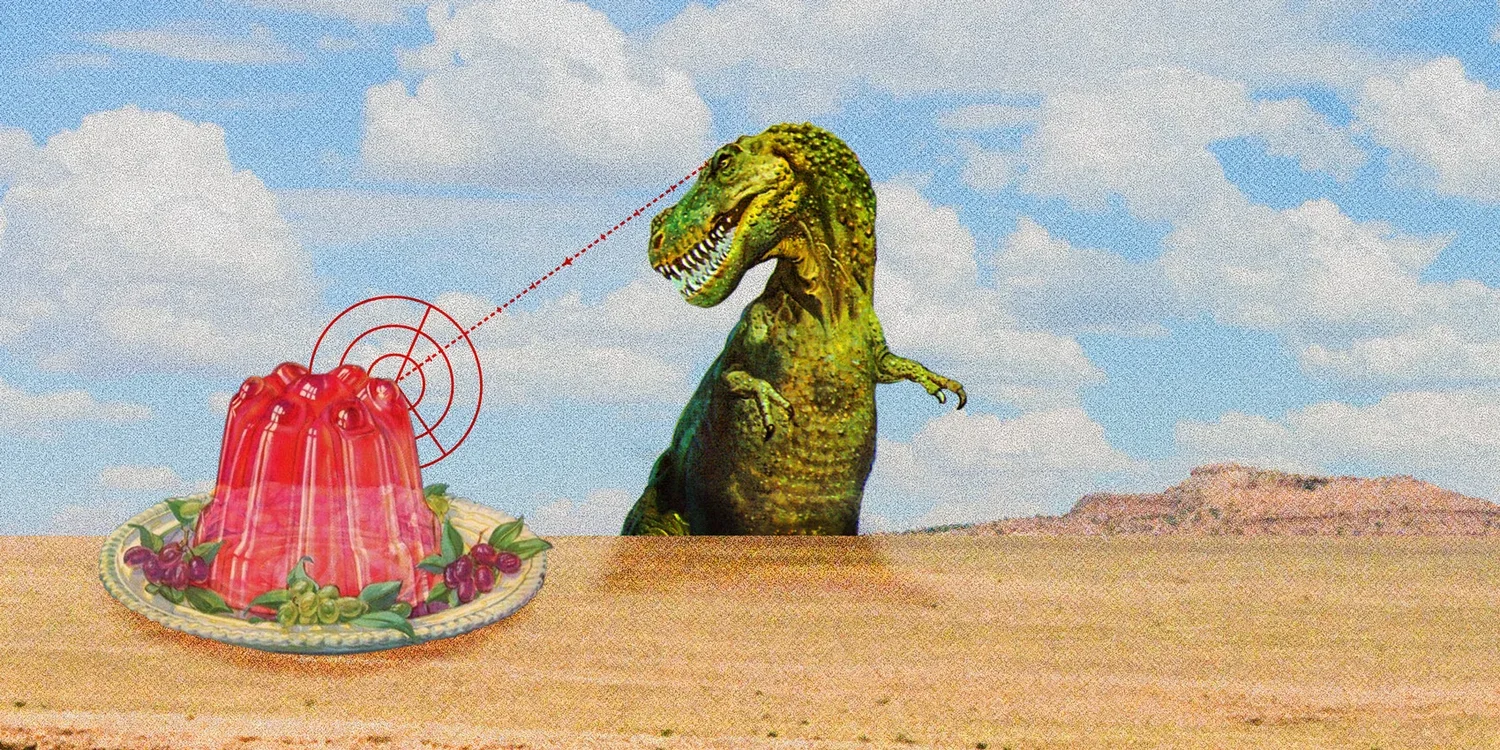Surreal collage-style artwork featuring a green Tyrannosaurus rex targeting a red Jell‑O dessert with graphic crosshairs, placed on a sandy desert scene with grapes, a plate, and a cloudy blue sky background.
