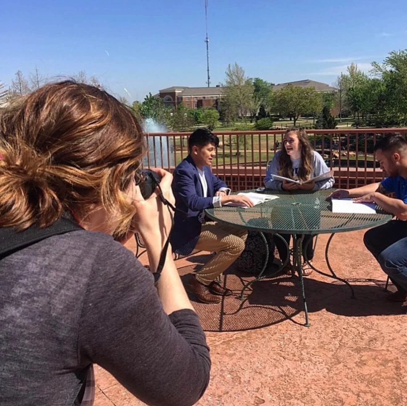 Emily Shelby, photographer, taking a photo of students on a college campus.