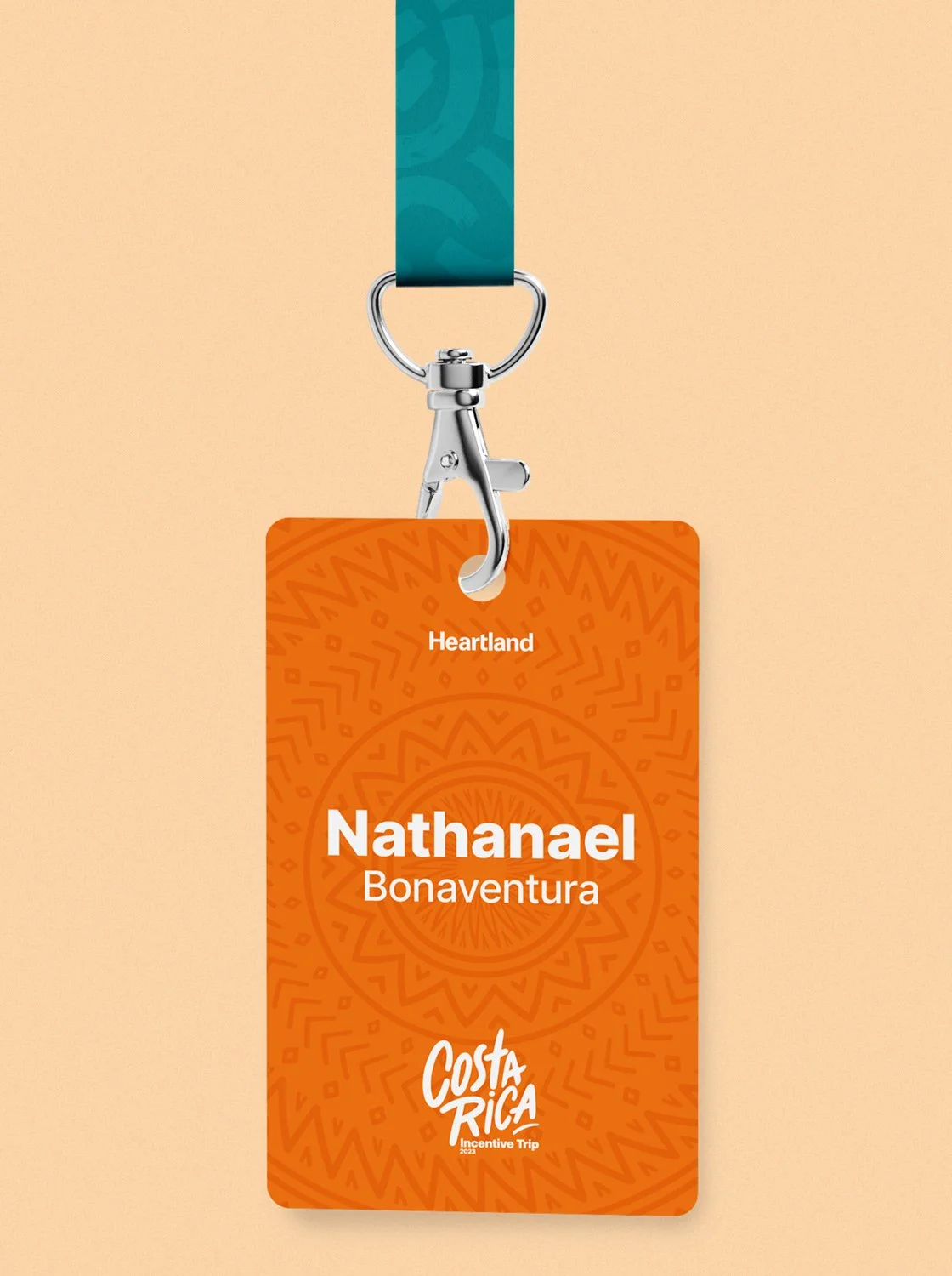 Close-up of a branded event badge with lanyard, featuring personalized name details and Costa Rica incentive trip branding, designed with a bold orange color palette and decorative pattern elements.