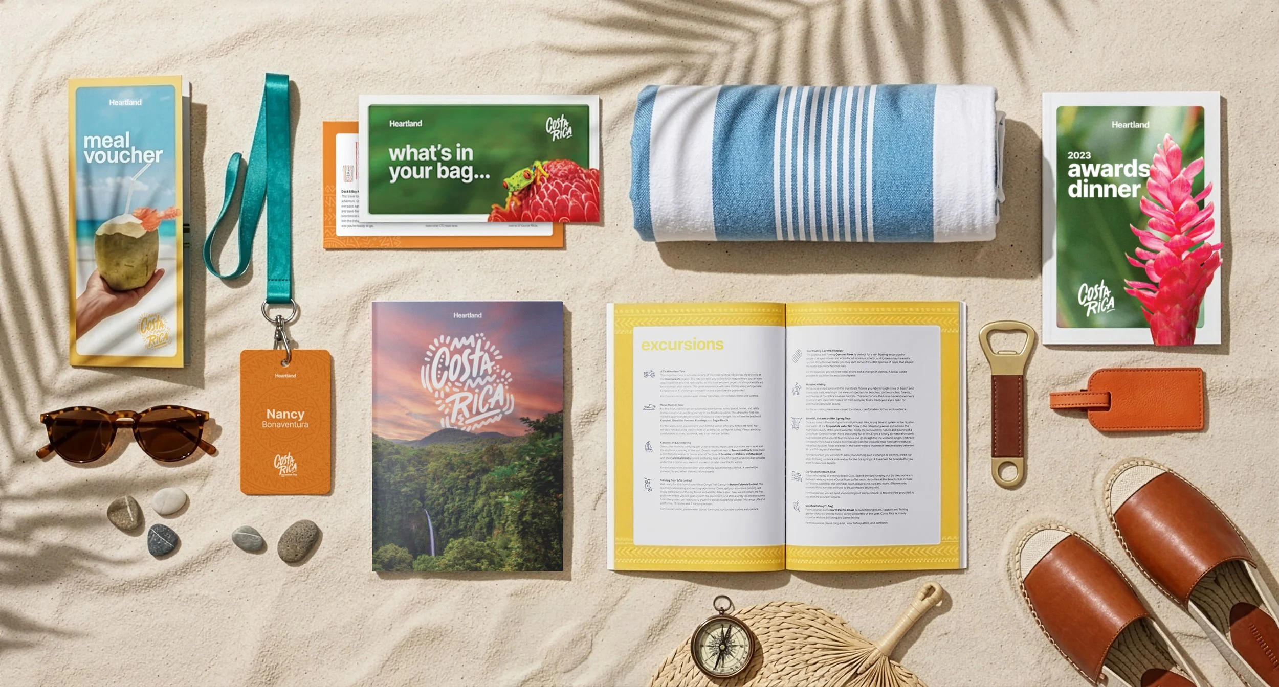 Lifestyle flat lay of a Costa Rica–themed incentive trip brochures, event badge, sunglasses, towel, guidebook, and accessories, styled on a sandy background to showcase branding and experiential design.