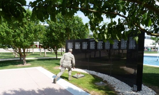 Chaplin Beck lays a flower at the memorial after reading names. 