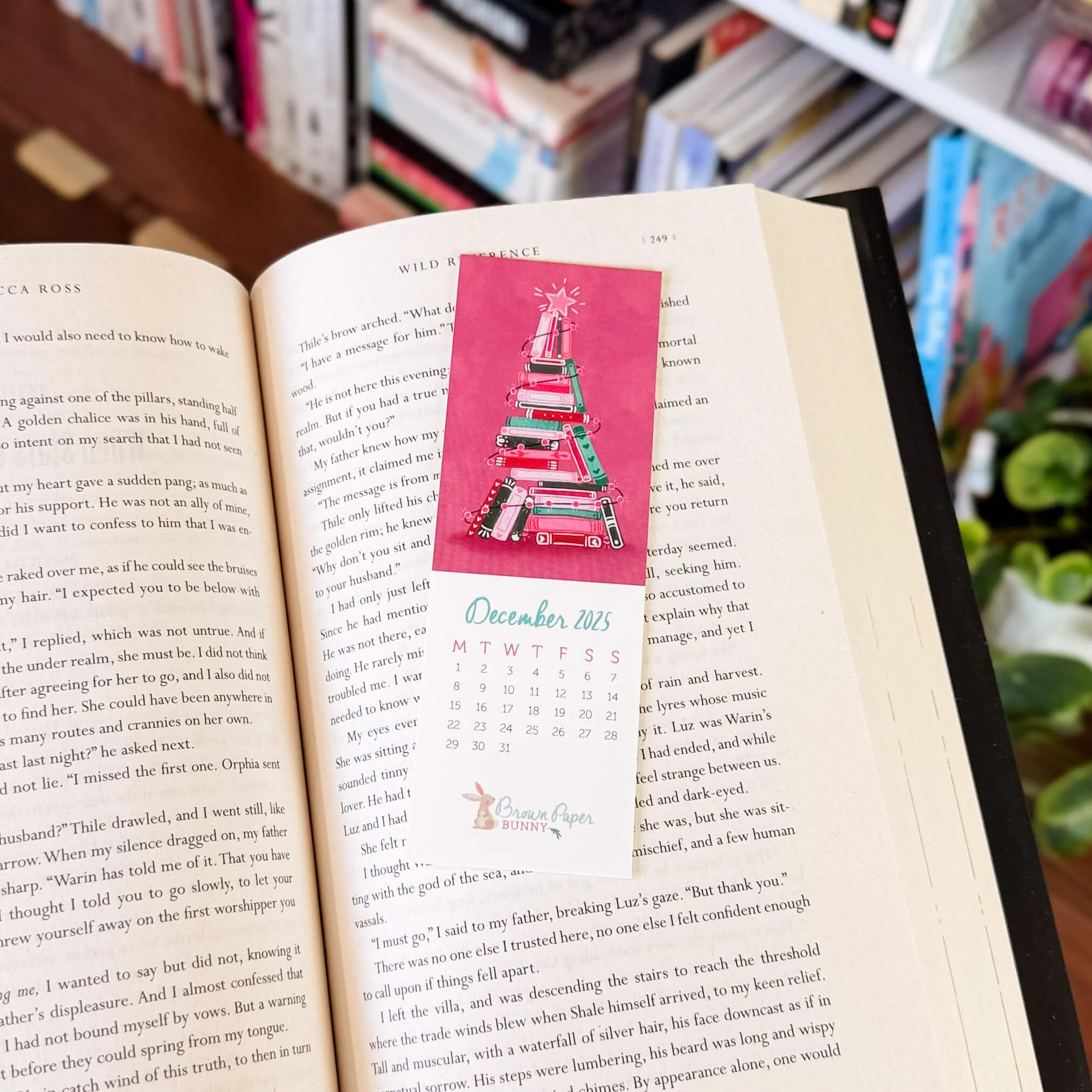 December Hoppy Mail bookmark with painted pink book tree on an open book background