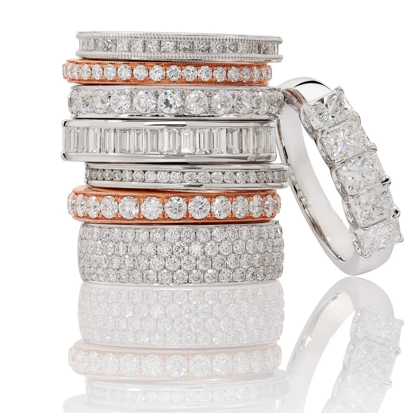 Stacked assortment of diamond and gemstone rings.
