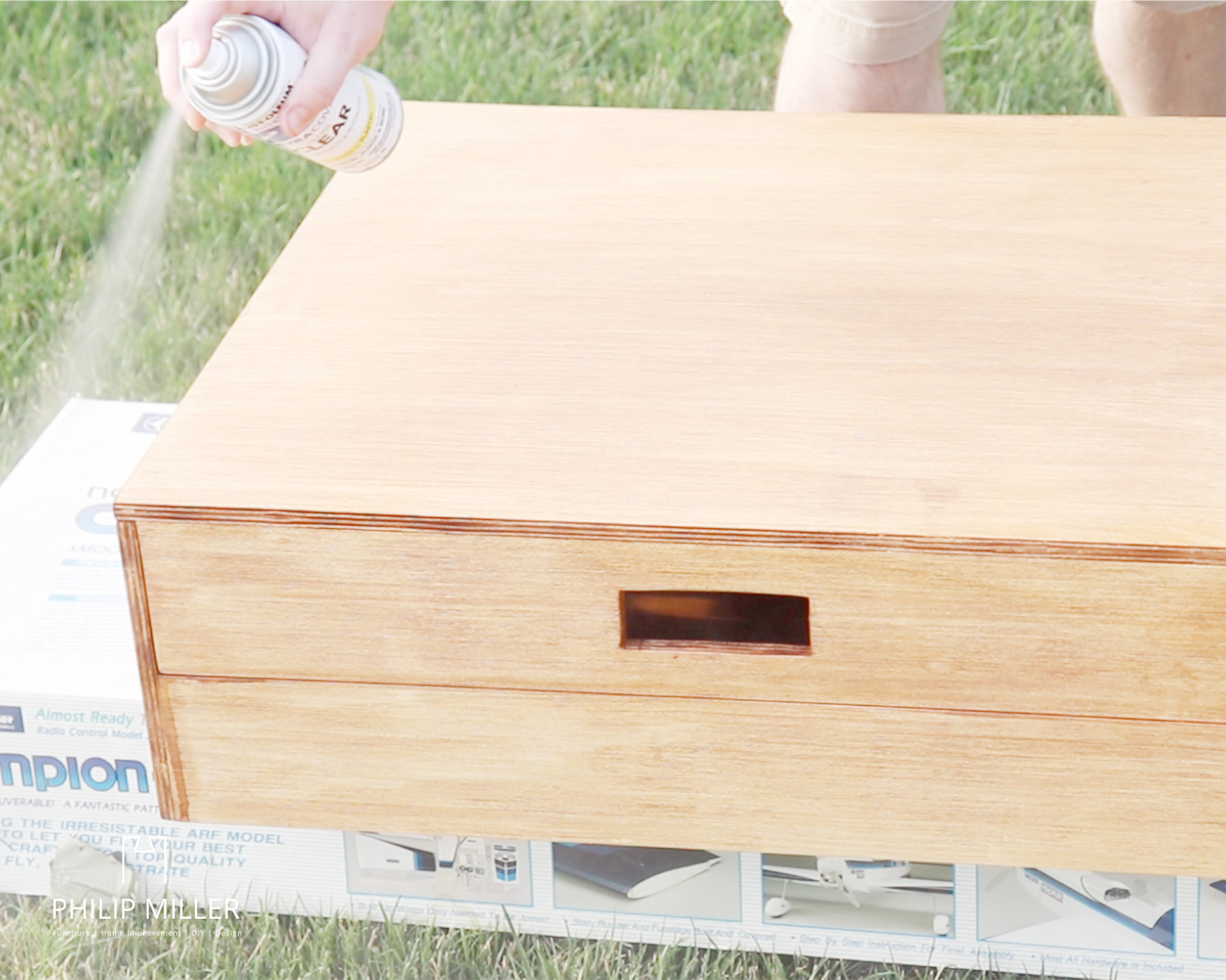 applying a clear gloss spray paint over the ring toss box