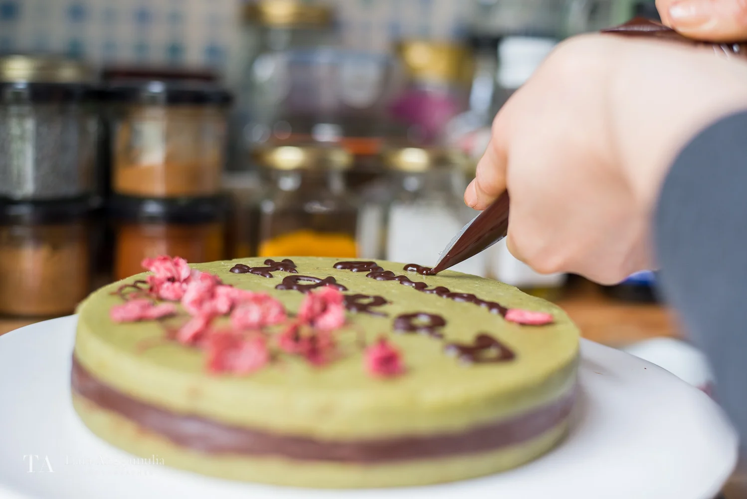 Decorating a raw chocolate and matcha cake.
