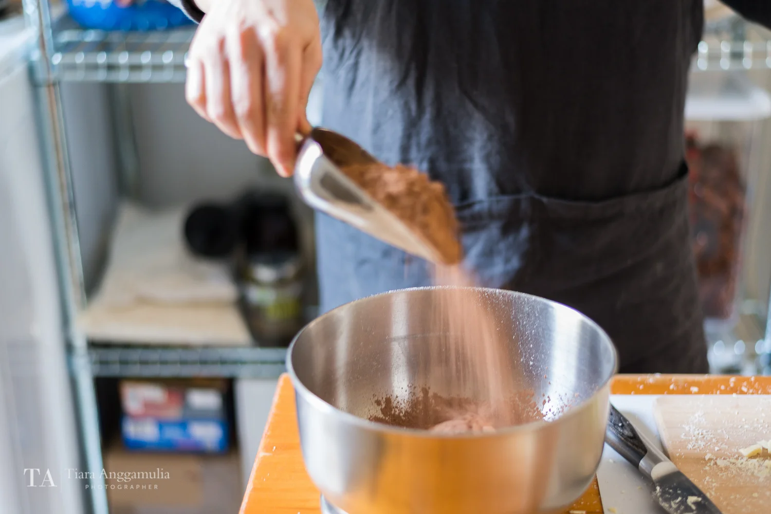 Putting cacao powder into the mixing bowl.