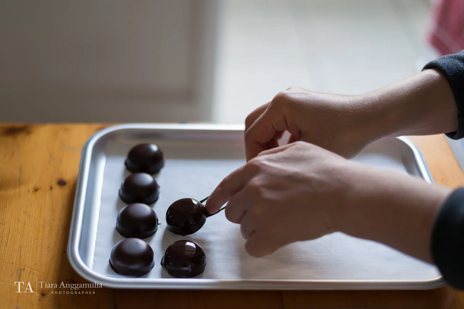 Raw bonbon on a tray after being dipped in dark chocolate.