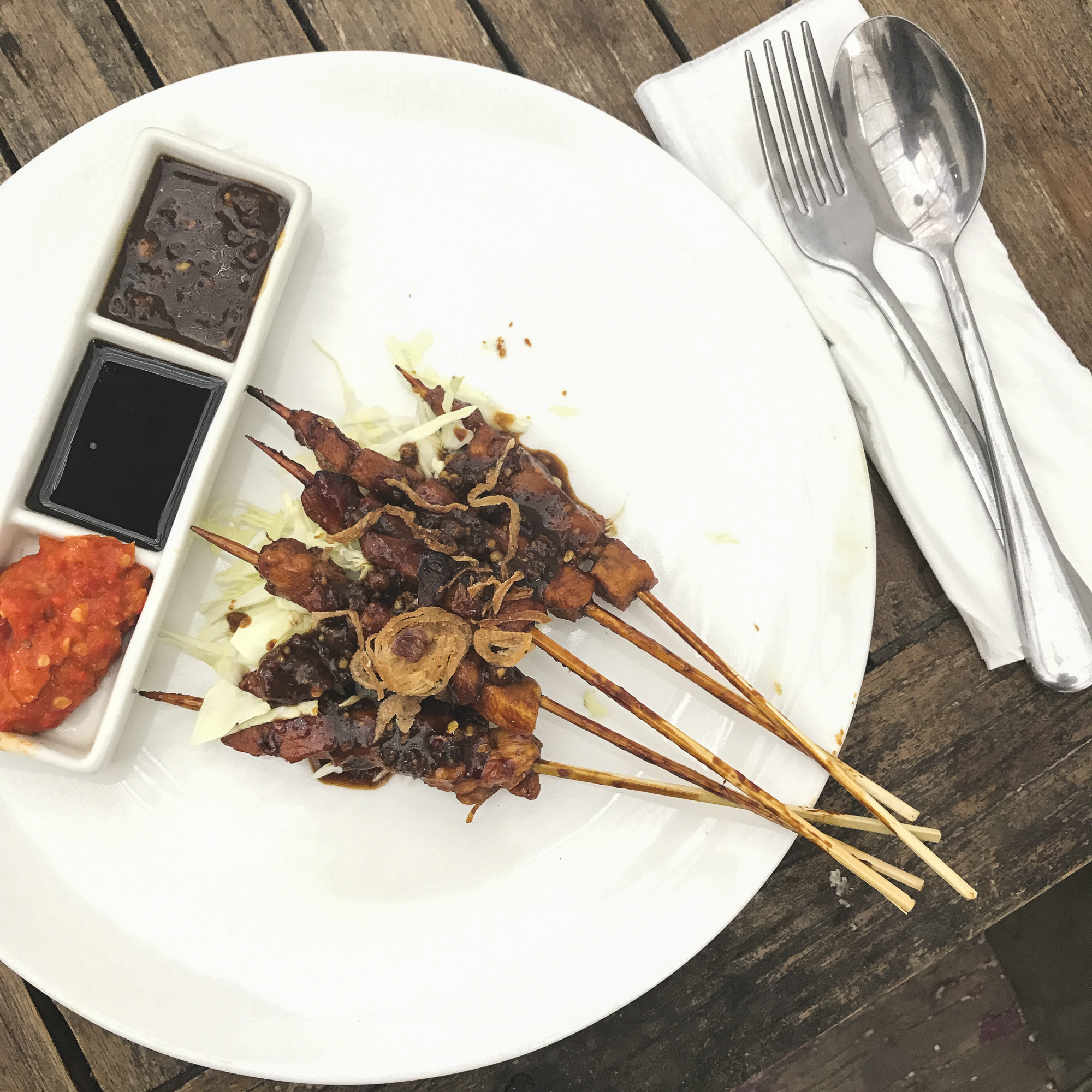  Freshly cooked chicken satay with condiments. 