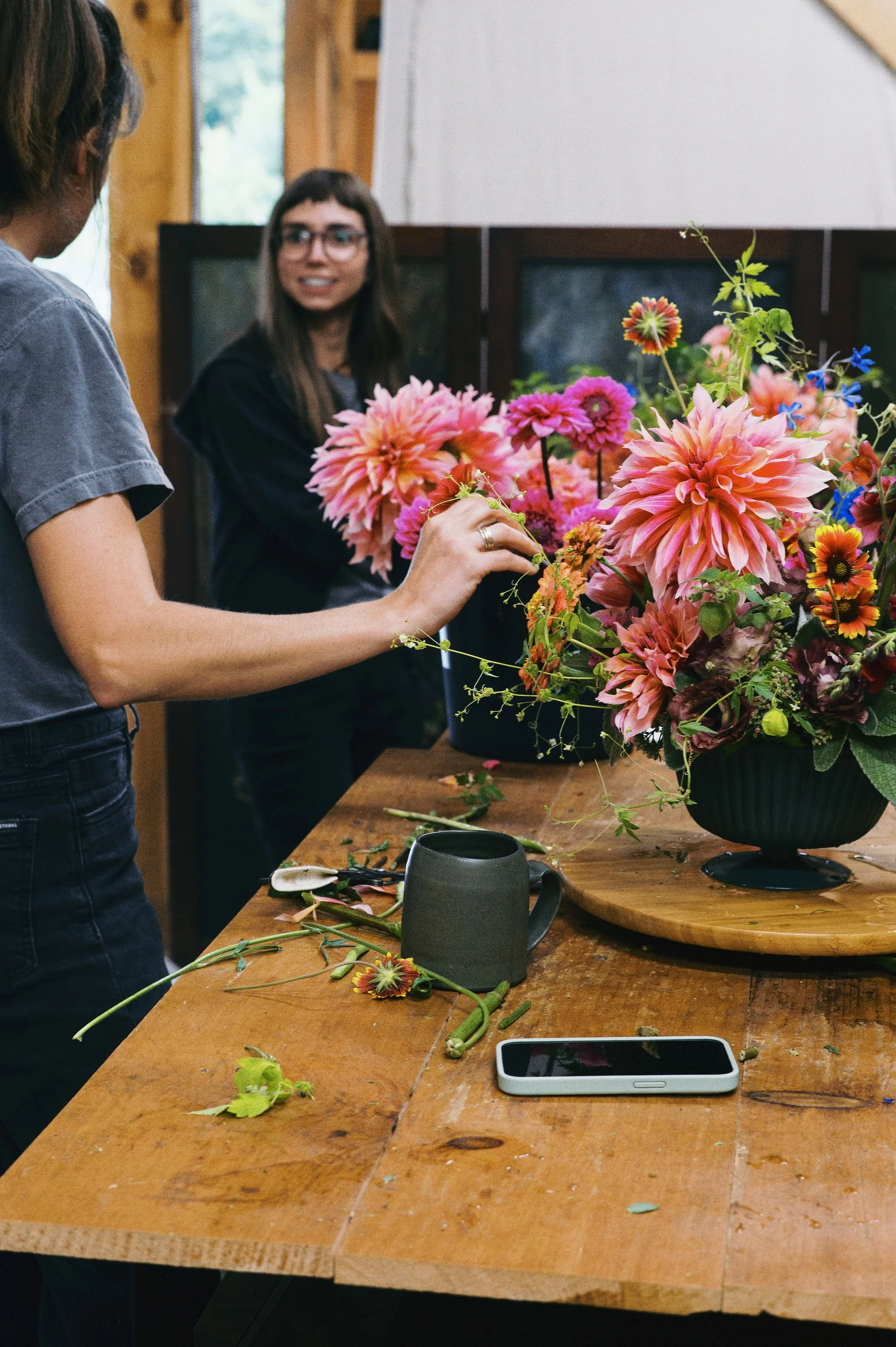 Freelance designer Ari smiling while designing flowers