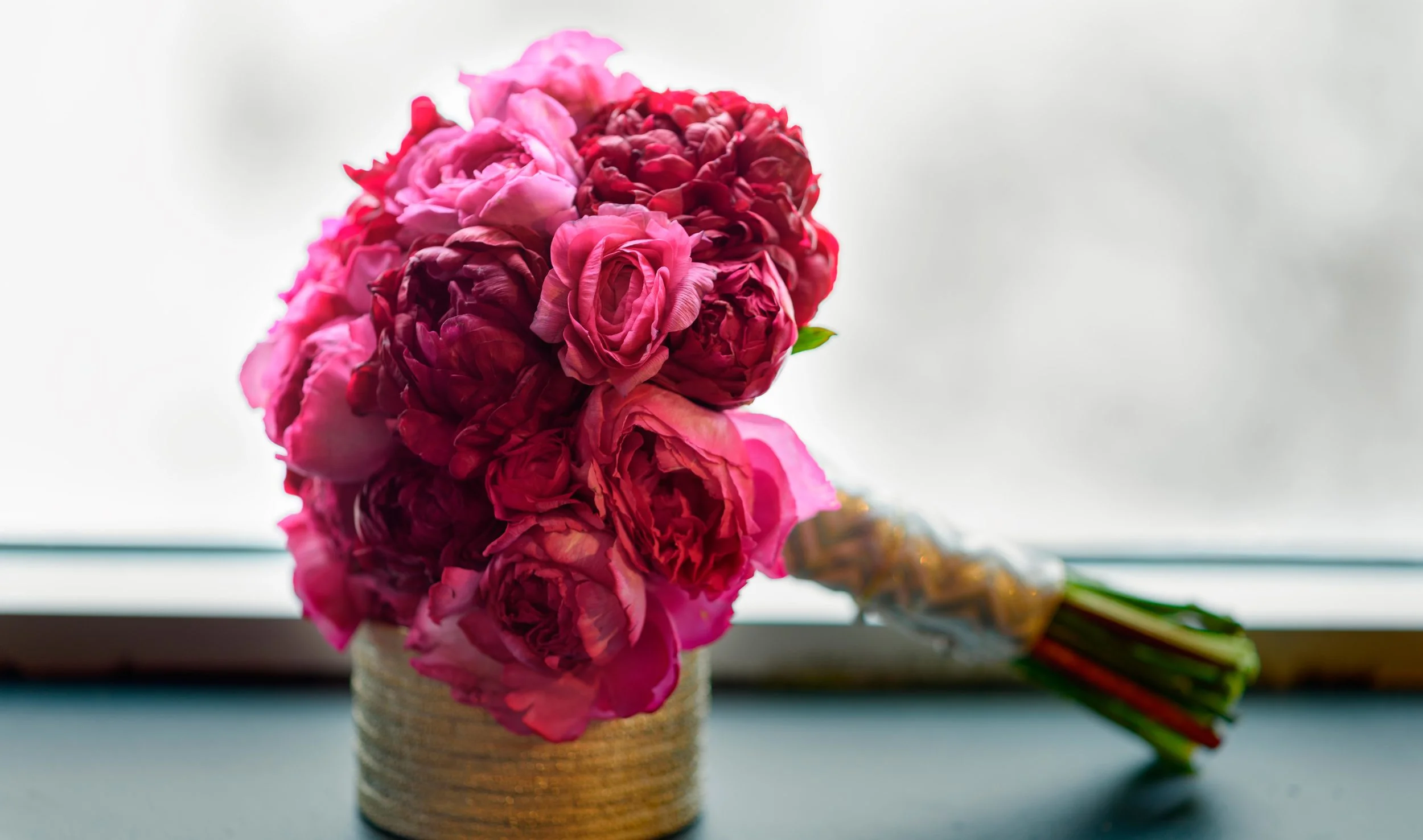 Bridal bouquet of Burgundy Peony, Magenta Yves Piaget Garden Roses and Ranunculus.
