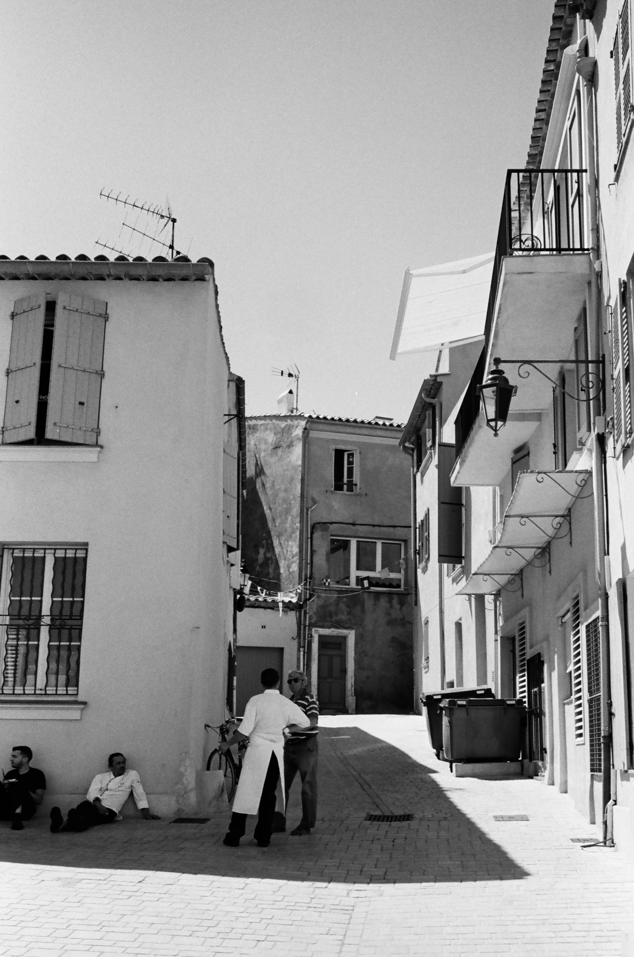 Restaurant workers take a break from the sun after a long lunch service, St. Tropez. France. 2016.