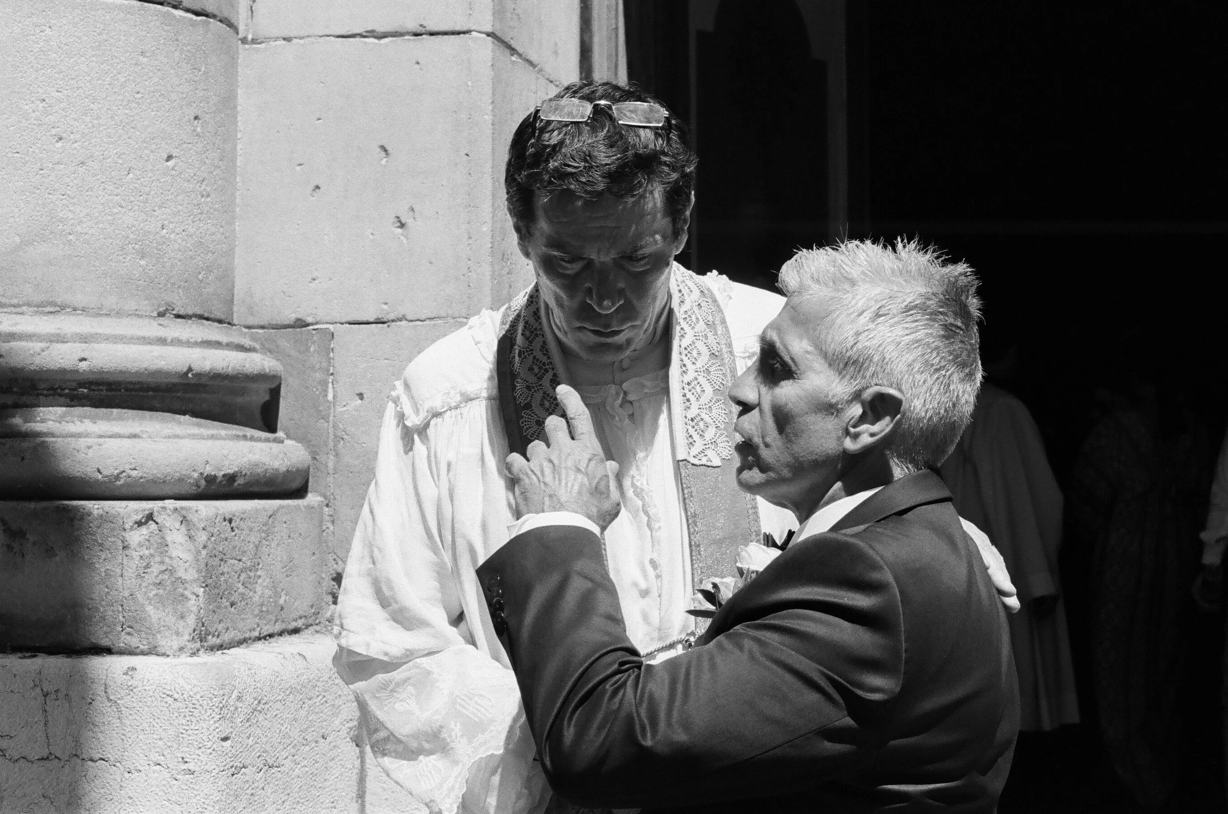 A priest listens intently to the father of the bride, St. Tropez. France. 2017.