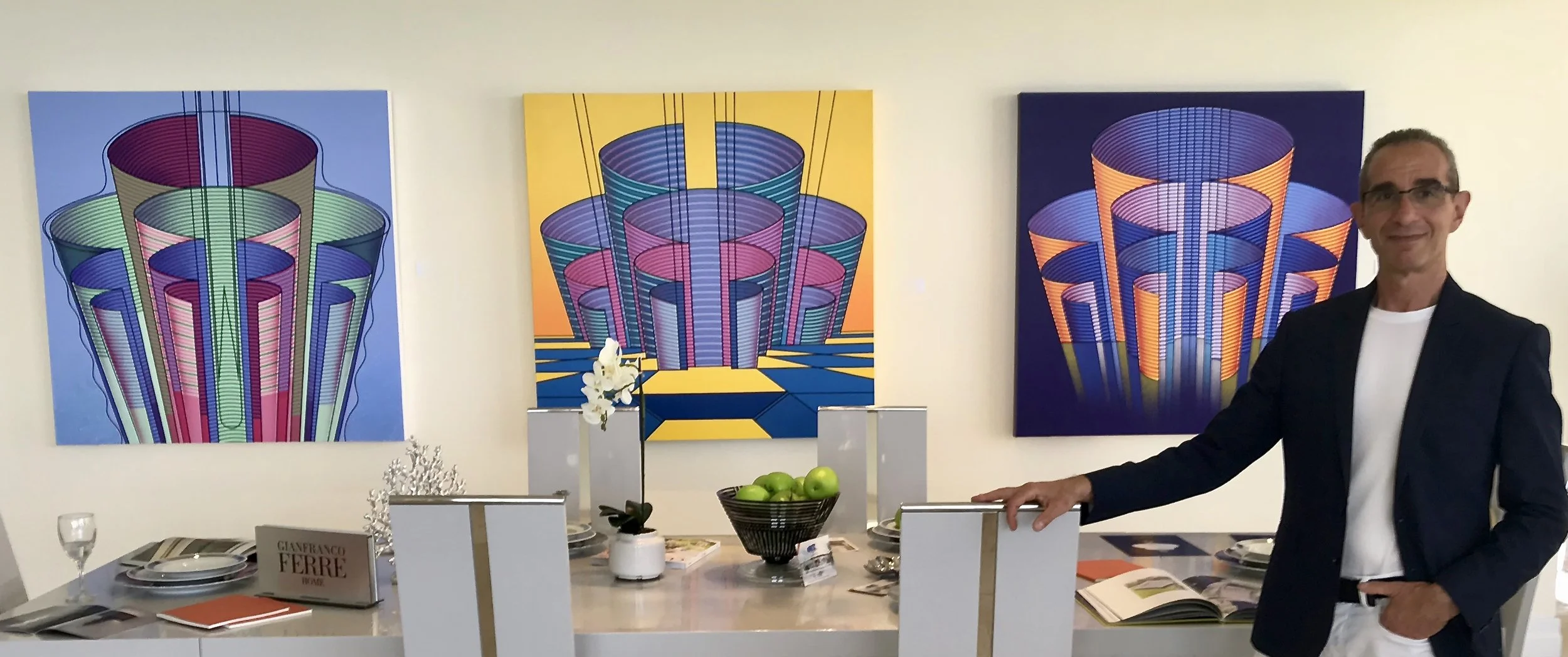 Sid Daniels standing with three paintings from thLabyrinth Series installed in a luxury residential interior in Sunny Isles Beach, Florida.
