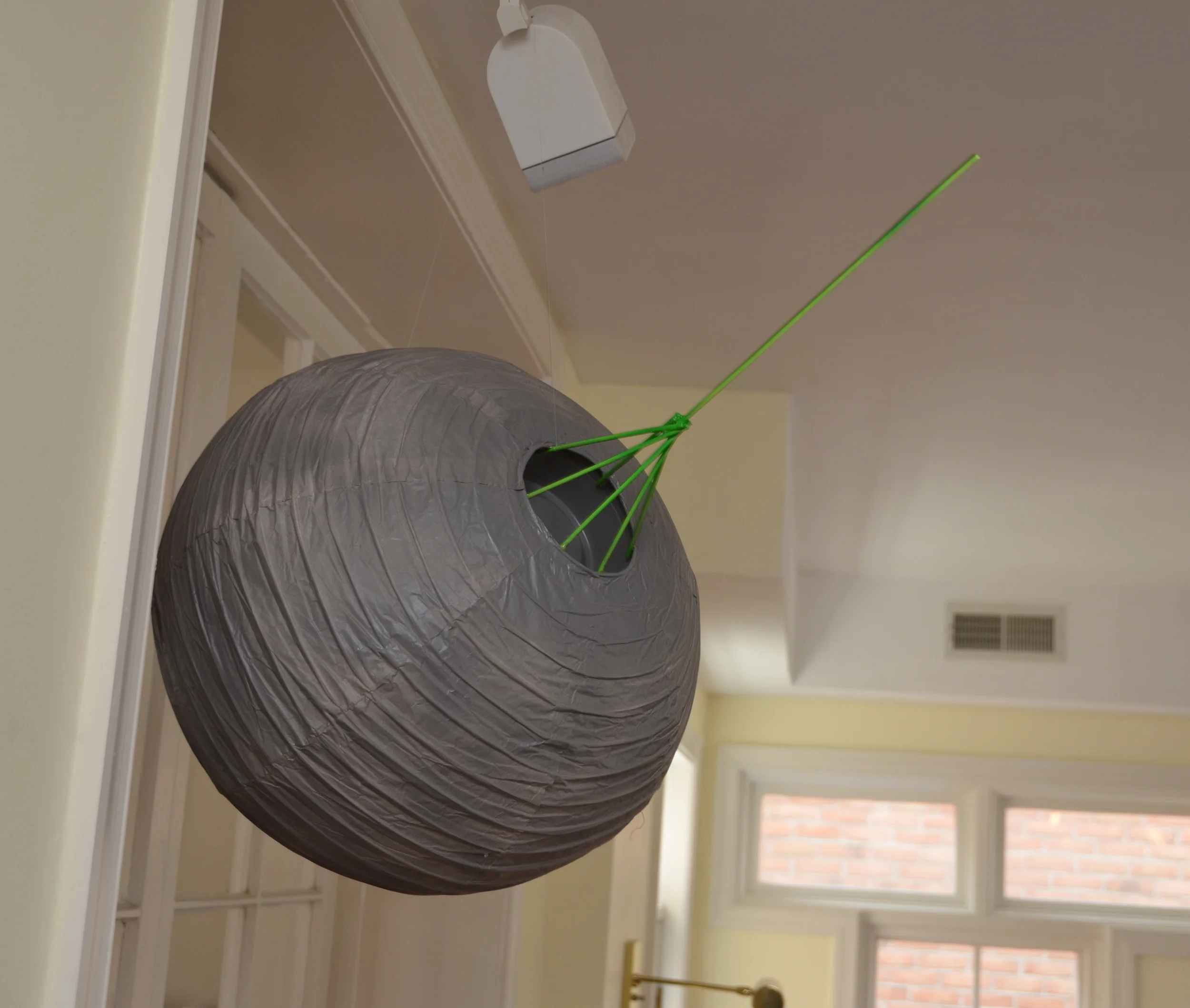 16" paper lantern painted gray; plastic Whole Foods container glued into the lantern hole and attached to a wooden, painted-green array of wooden dowels.