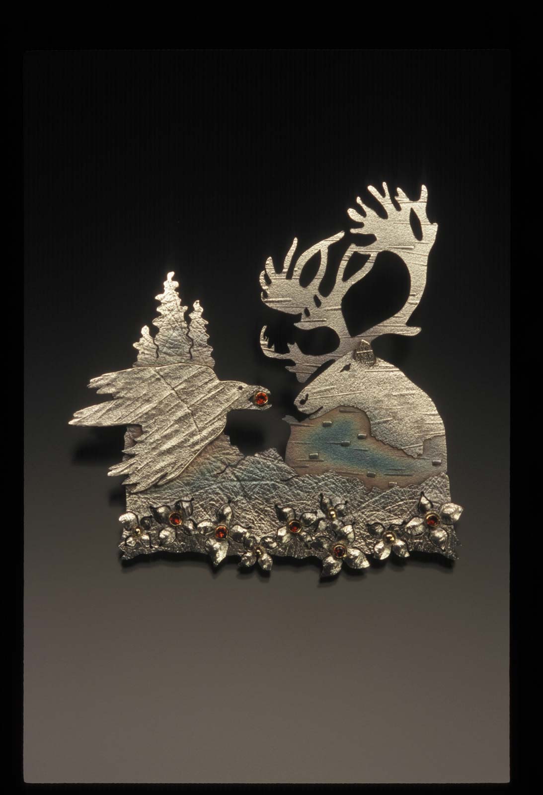 RAVEN AND CARIBOU: A DENA’INA STORY pendant of sterling silver, fourteen karat gold and garnets, 6.03 x 8.26 x 0.64 centimeters, 2007.
