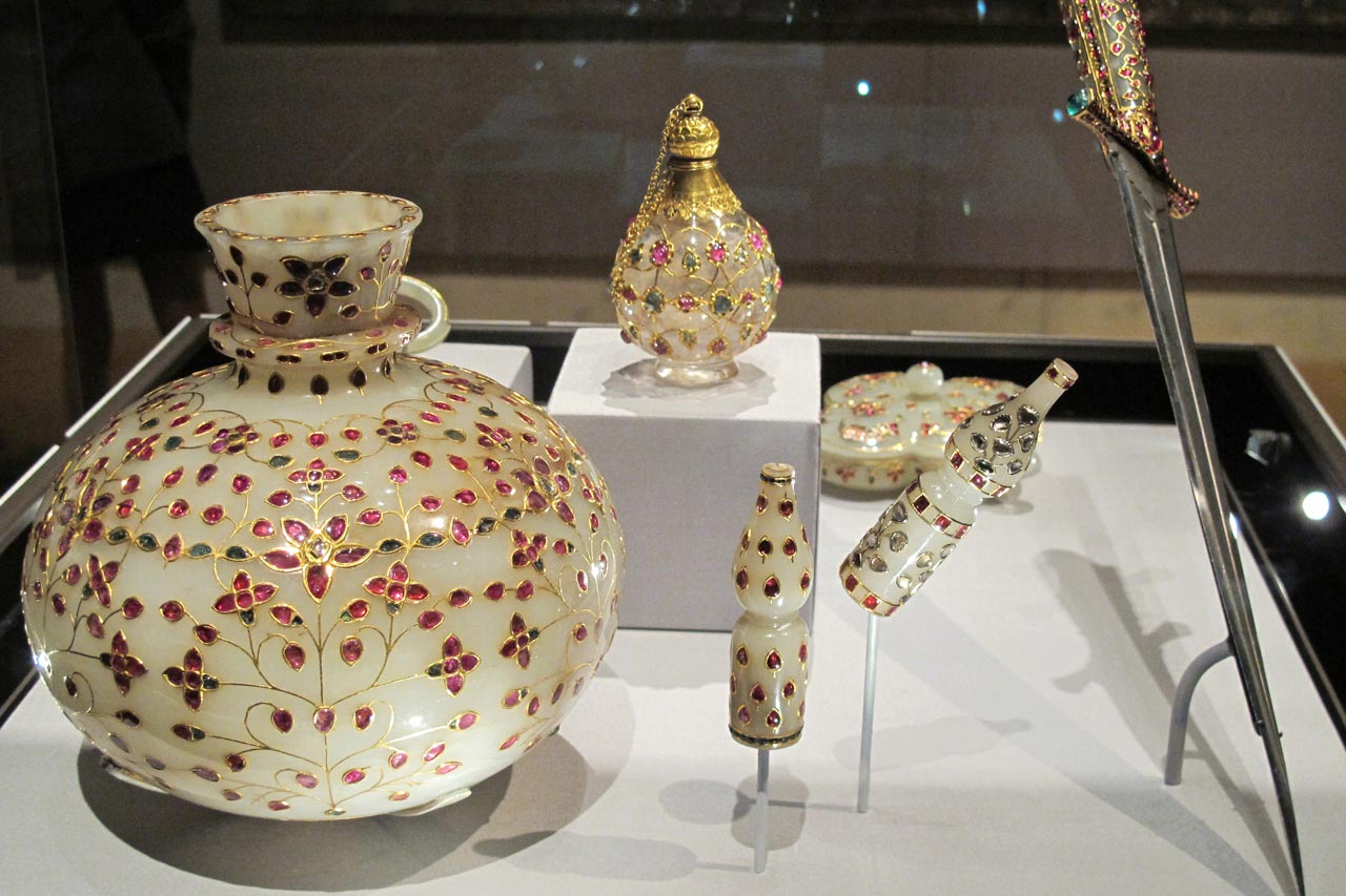 Shown are a base of a waterpipe, two huqqa mouthpieces, a dagger with a jeweled hilt.