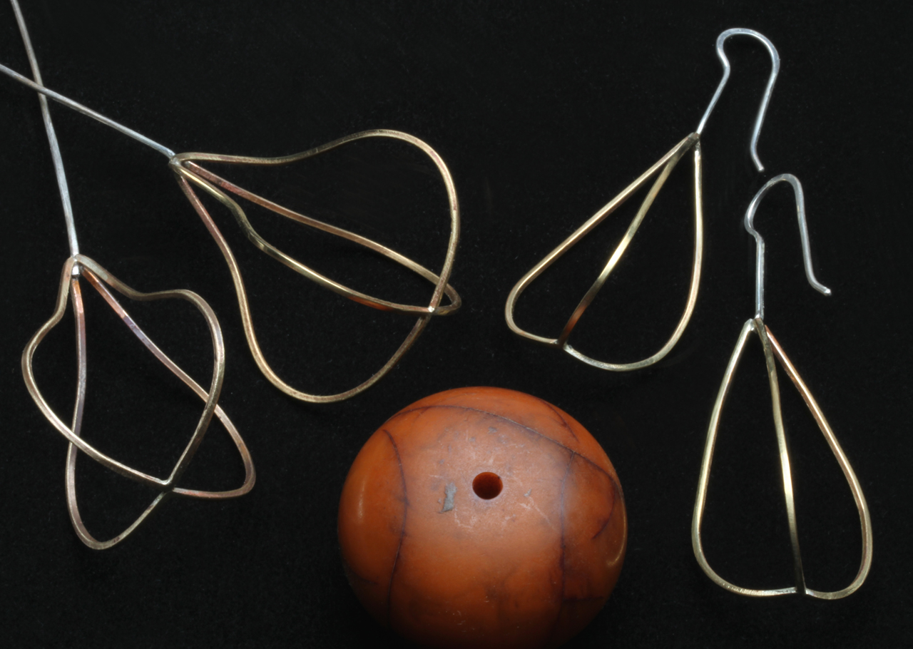 IN PROCESS FIG/PEAR-SHAPED AND POD EARRING MATRICES, shown with a bakelite bead (3.2 cm diameter), imitation of copal from the African trade, that I used as a forming mandrel for the square wire matrices, which are soldered at top and bottom. Earwires are 18 gauge sterling silver, and bent, forged and buffed smooth.