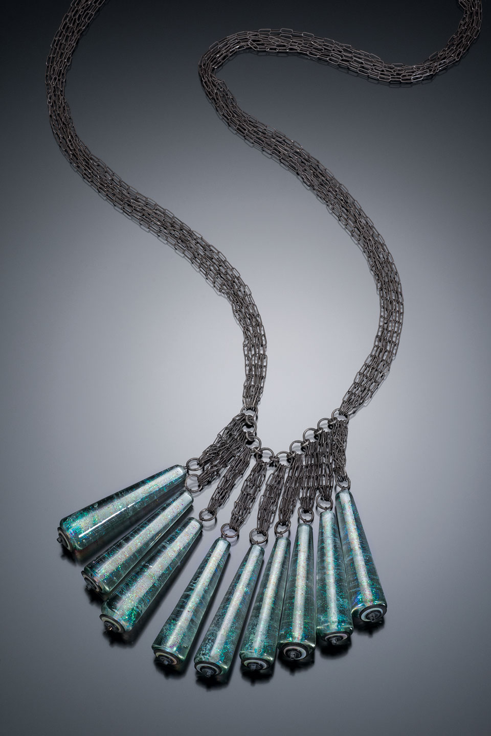 THE BLUE DOVE NECKPIECE of torch-formed soda lime and dichroic glass, hand-fabricated, oxidized sterling silver chain; glass components sewn on with cable, 8 x 5 x 76 centimeters, 2015. Photograph by Robert Diamante.