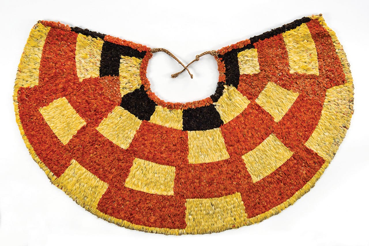 ‘AHU ‘ULA cape of red ‘i‘iwi ( Vestiaria coccinea ) feathers, yellow and blank ‘o‘o ( Moho sp.) feathers, and olona ( Touchardia latifolia ) fiber, 70 x 107 centimeters, early nineteenth century. Bernice Pauahi Bishop Museum, Ethnology Collection. 