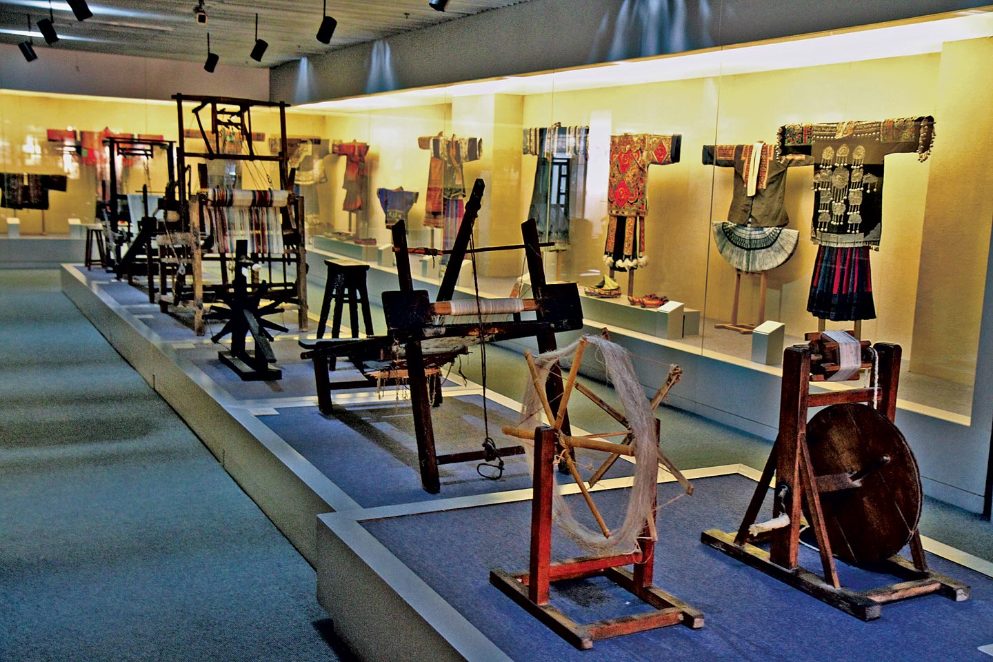 CLOTHING GALLERY, with spinning fixtures and weaving looms in foreground. Such textile furniture has also been preserved in other museums. Photographs by Robert K. Liu and Patrick Benesh-Liu/ Ornament; shot hand-held, with high-ISO and no flash, to prevent light damage.
