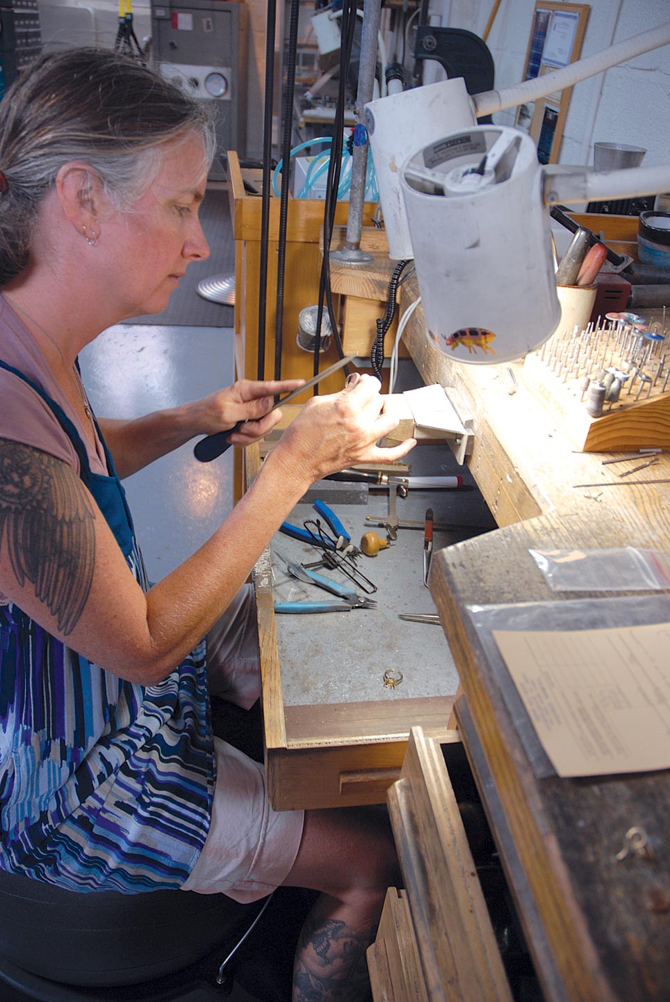 CAROL ROHMANN GREENE, Marraccini’s assistant, working at her bench.