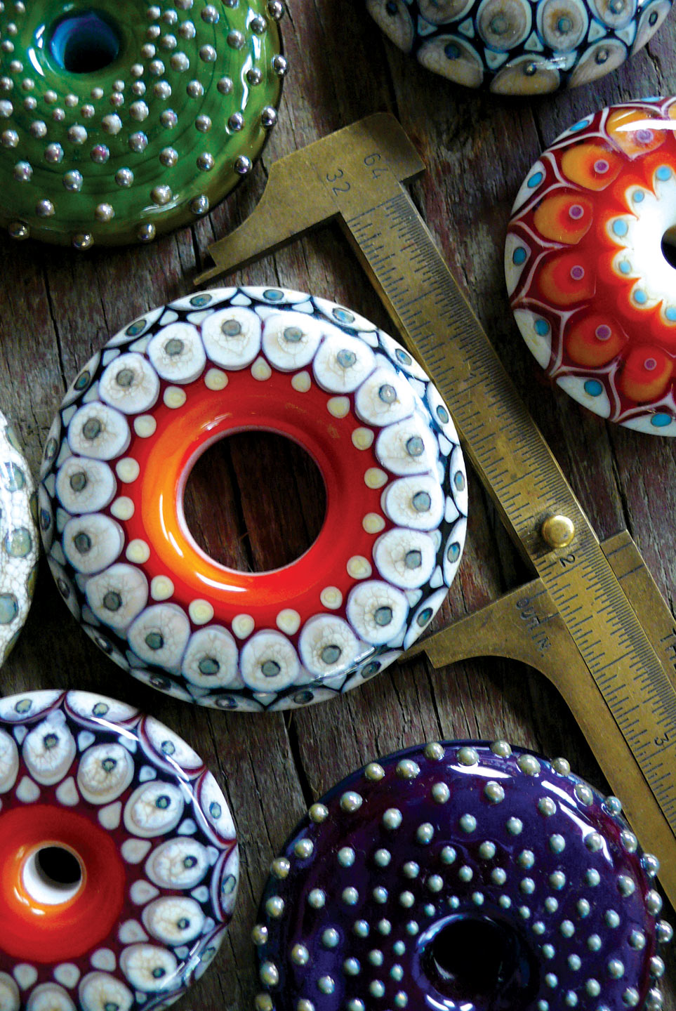 COLLECTION of large disk beads in flameworked glass, 5.08 centimeters diameter, 2016. Photograph by Kristina Logan.