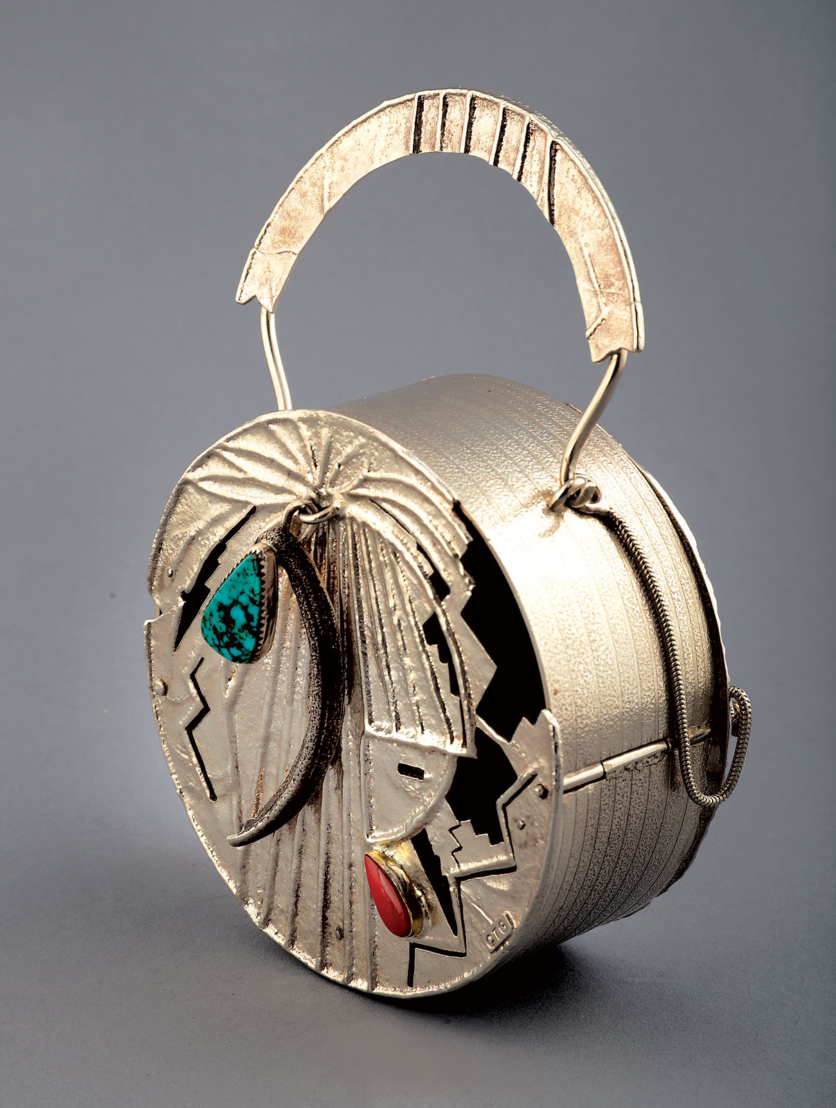 CASINO LOOT BAG by Connie Tsosie-Gaussoin of sterling silver, bezel set Royston turquoise, Italian coral in gold bezel, tufa cast feather design with fabricated silver sheet, 2012. Photograph by Carolyn Wright.